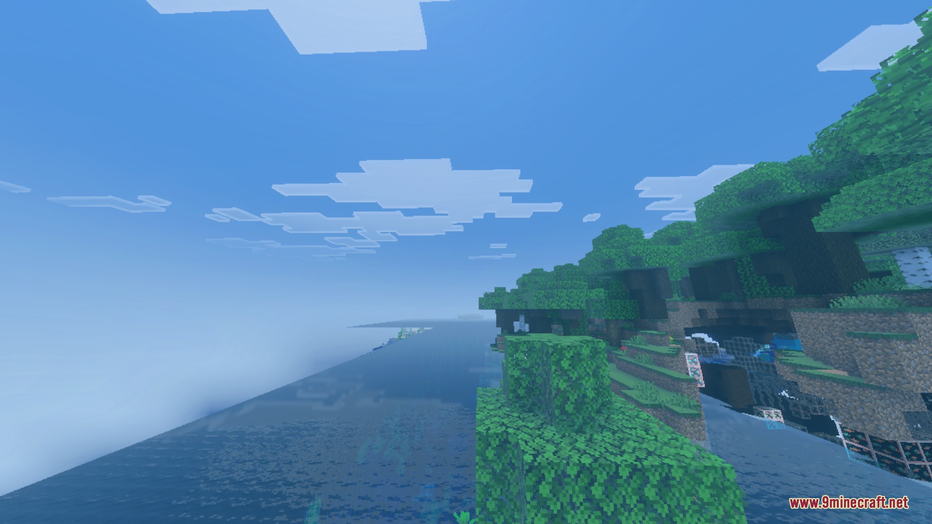 A scenic Minecraft coastline featuring lush green forests and clear blue water