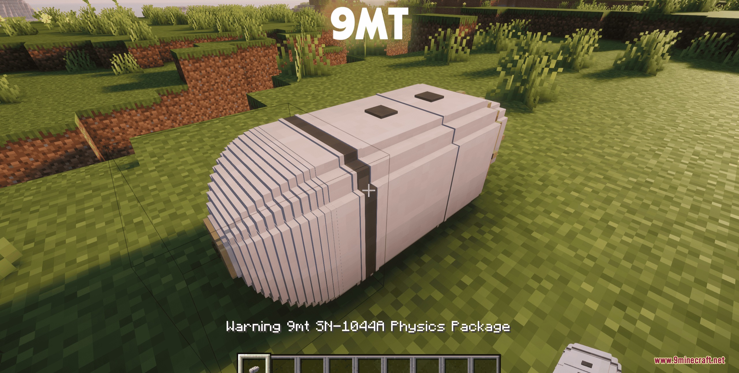 A large white nine megaton nuclear bomb package sitting on the grass
