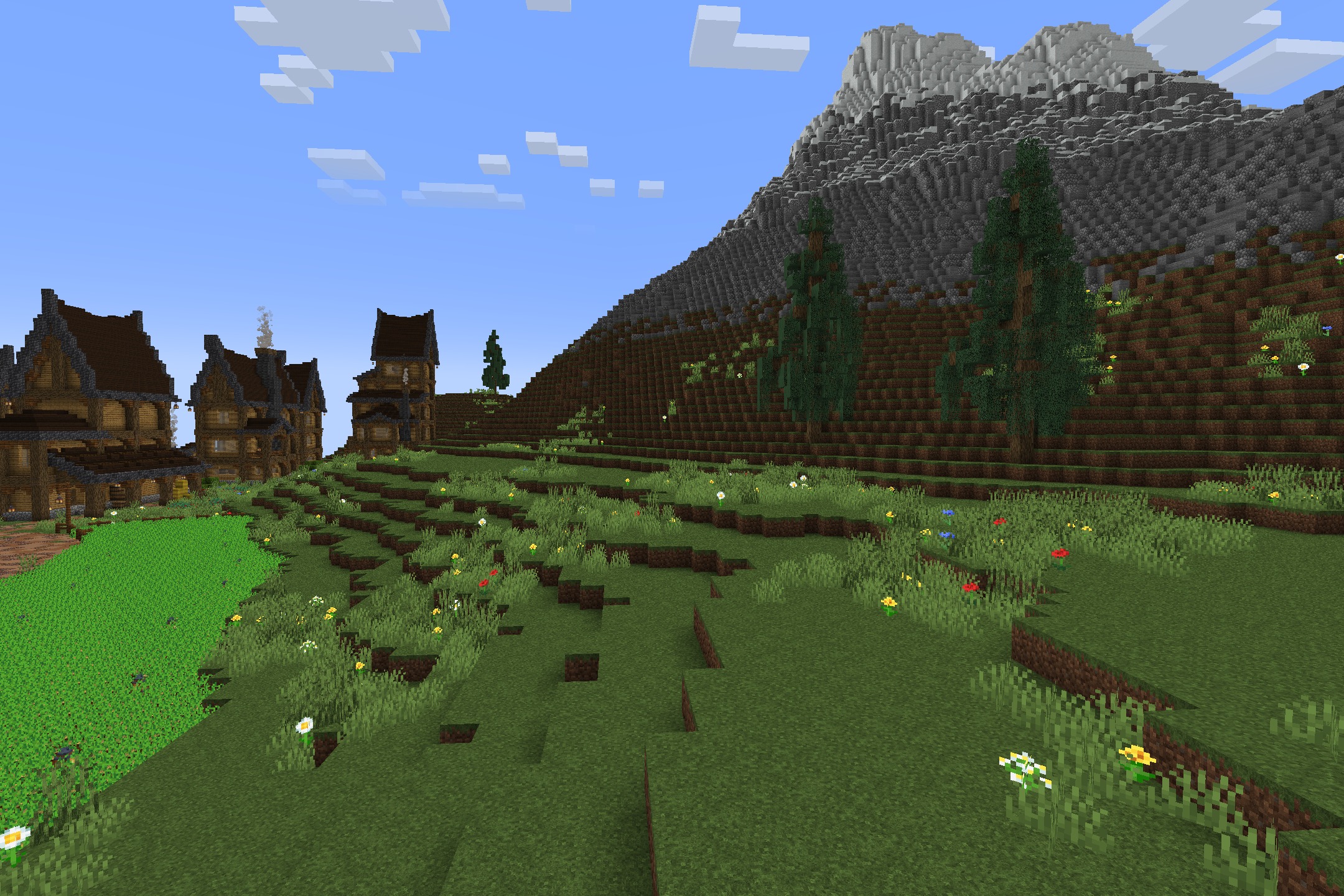 Realtastic X512 PBR POM Resource Pack Screenshot 4 Scenic mountain landscape with detailed grass and flowers in a Minecraft world