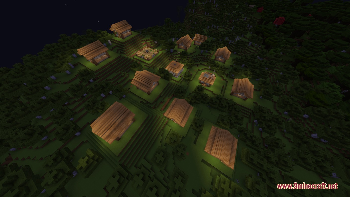 Aerial view of a peaceful village with lit houses in a dark forest