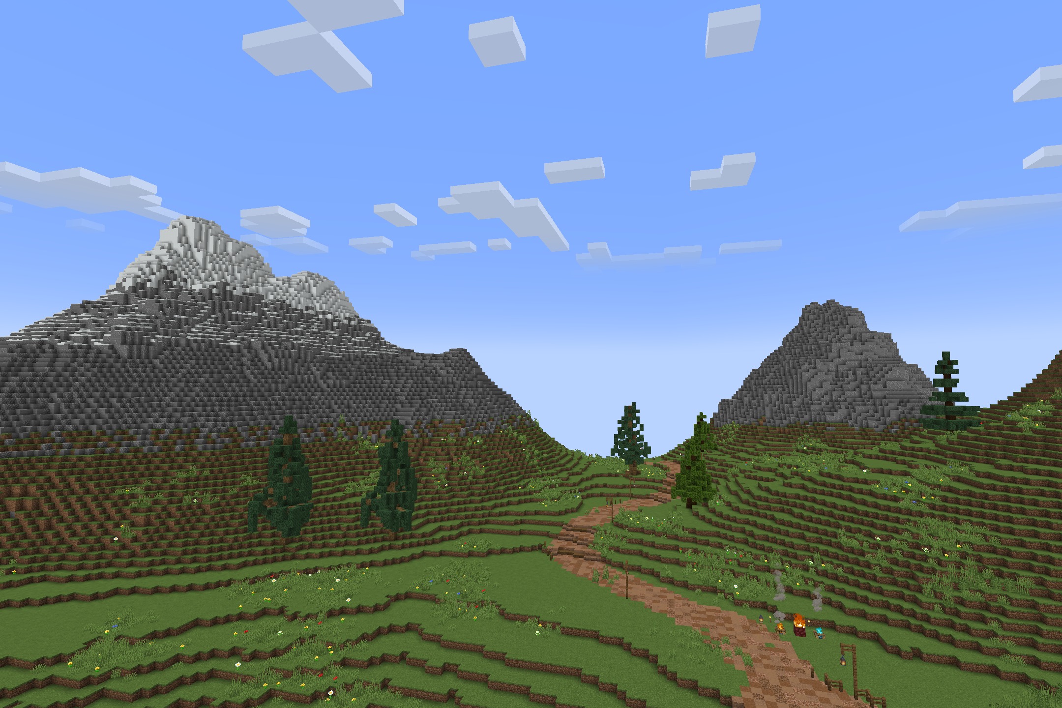 A vast Minecraft landscape featuring tall mountains and a winding dirt path