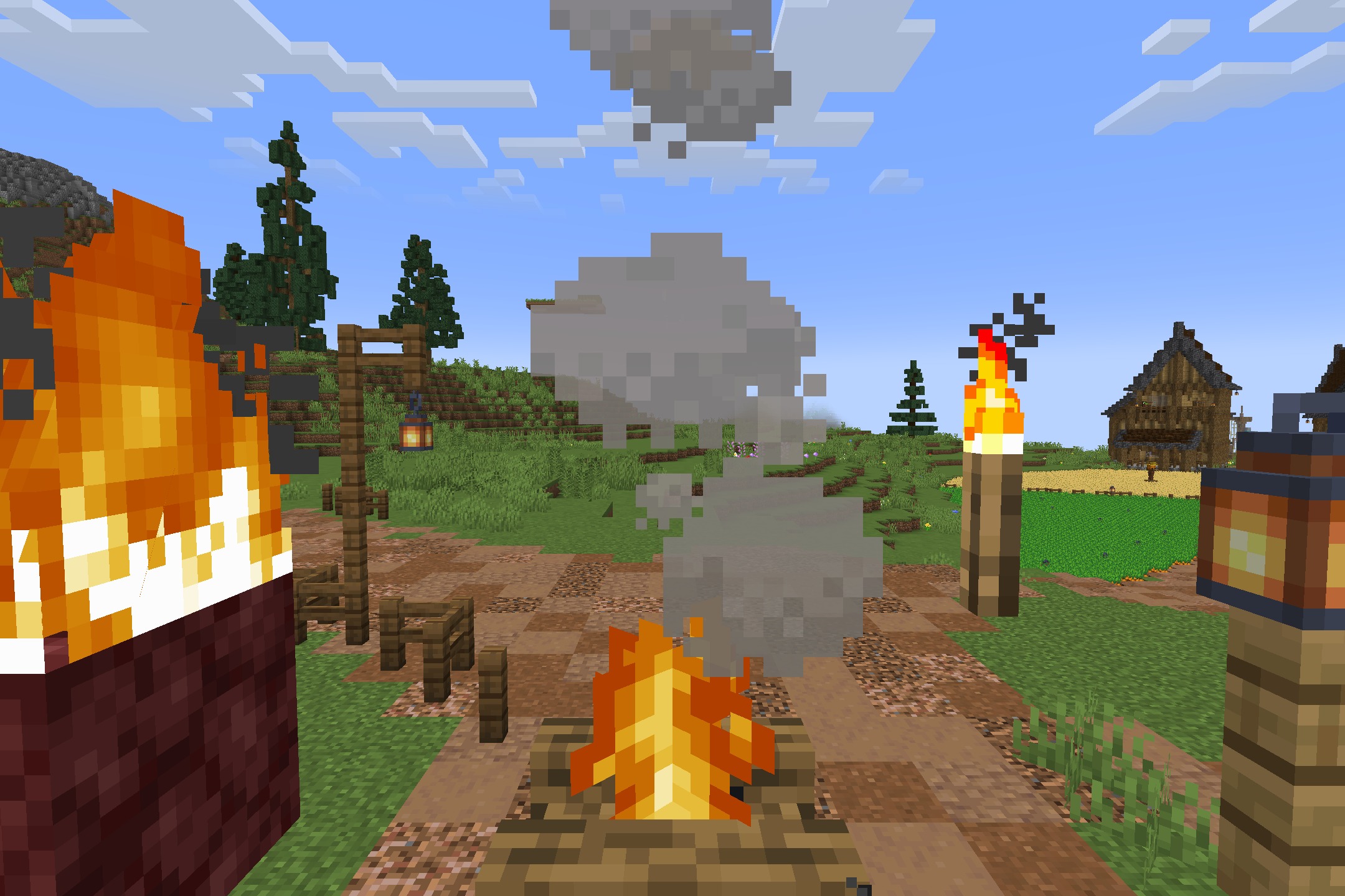 A burning campfire with smoke rising near a wooden post and village house
