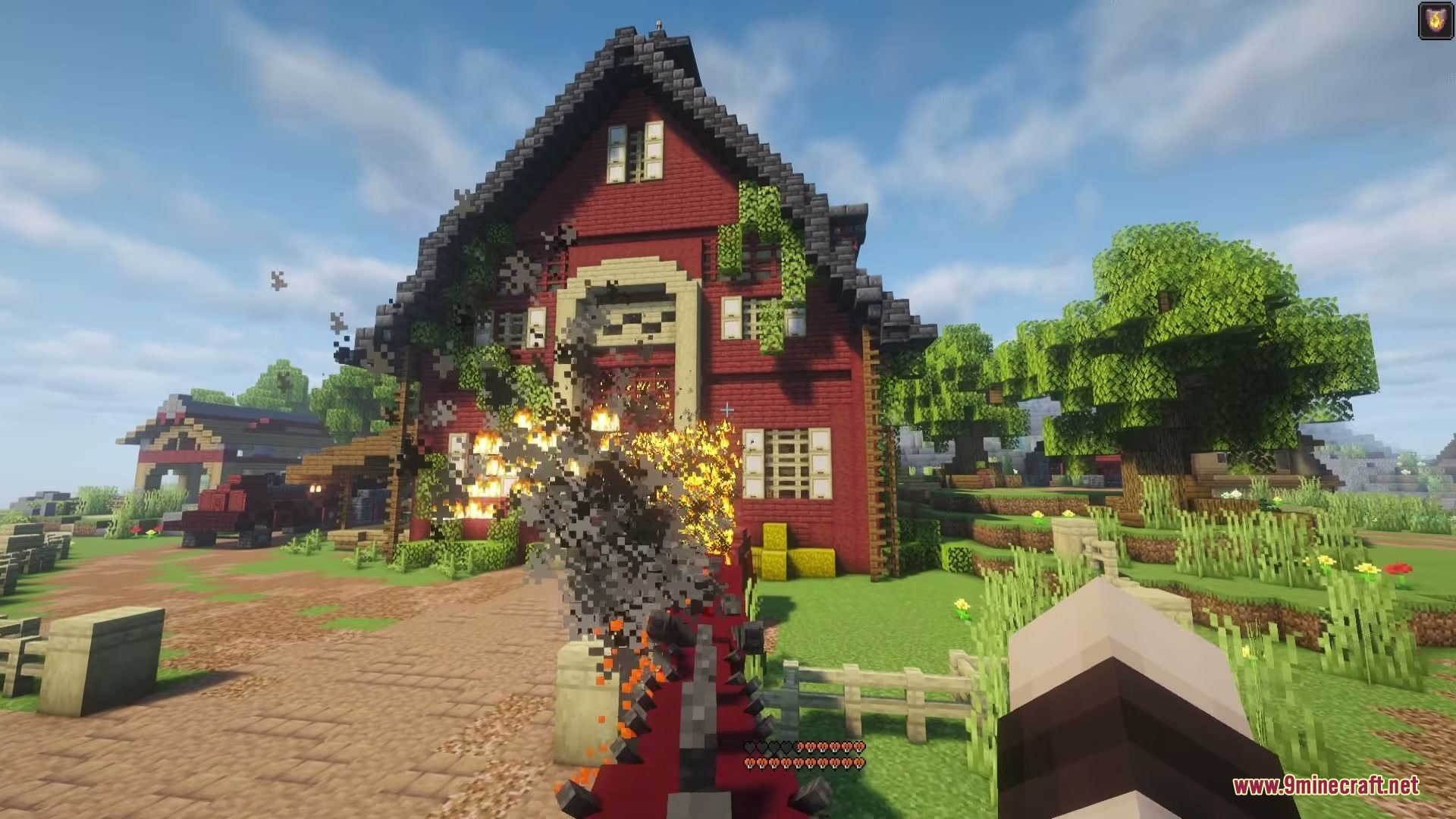 Riders of Dragons Mod Screenshot 8 A dragon breathing fire at a large red barn in a Minecraft village