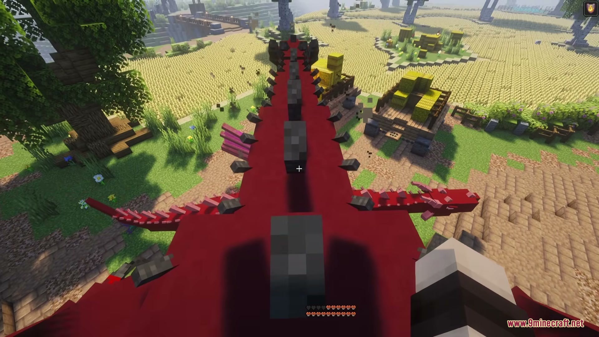 Riders of Dragons Mod Screenshot 9 A player riding a large red dragon over a Minecraft village