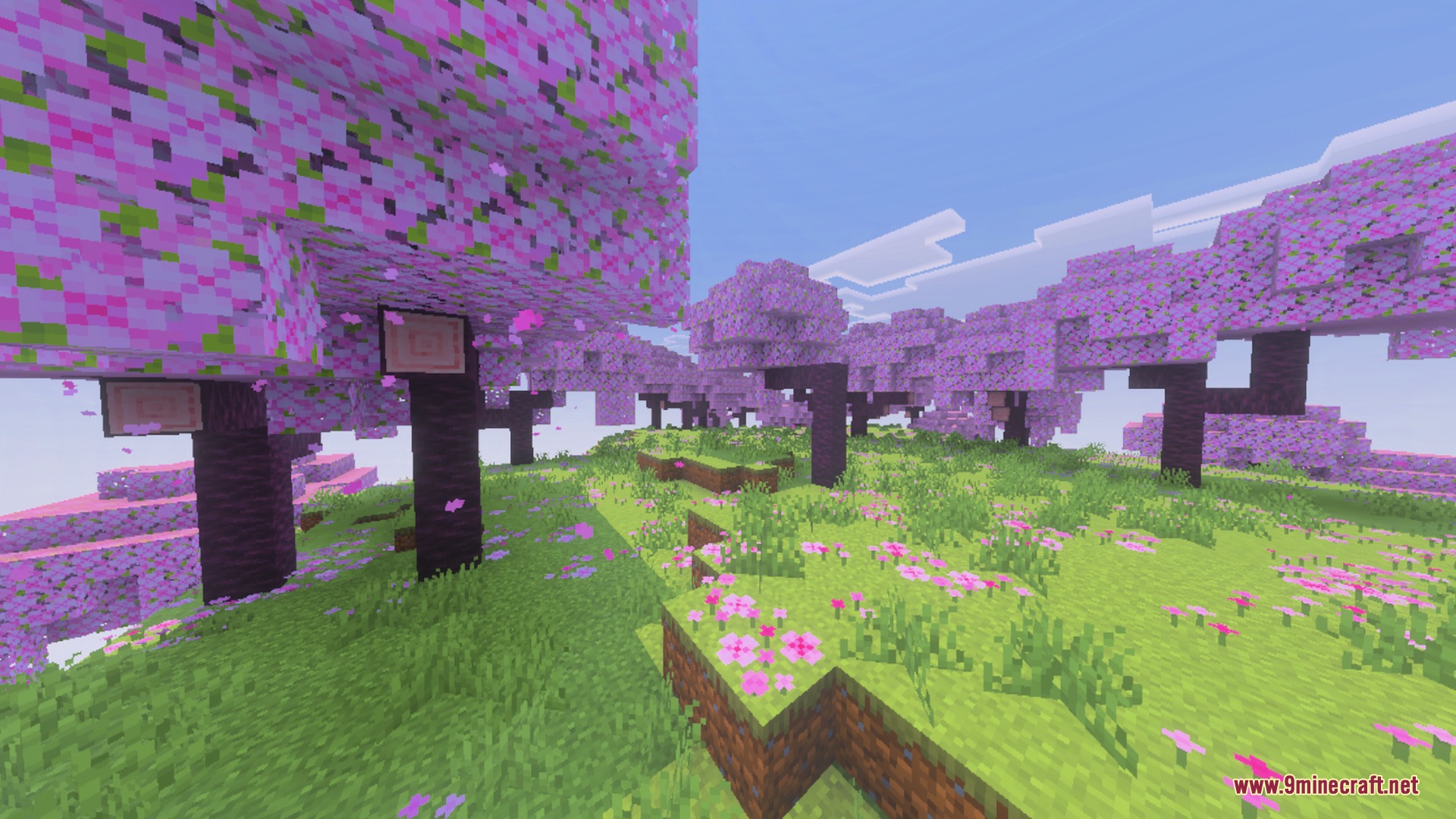 Vibrant cherry blossom trees with pink leaves and bright green grass blocks