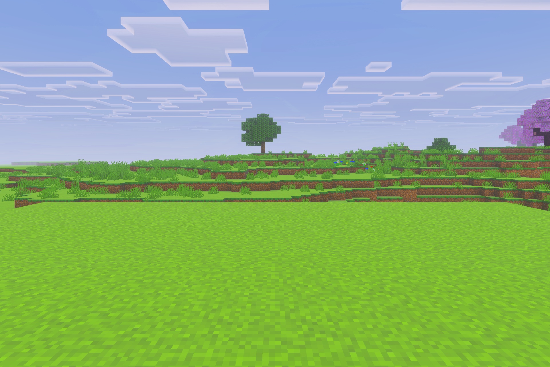Vibrant green landscape with a single tree under a bright blue sky