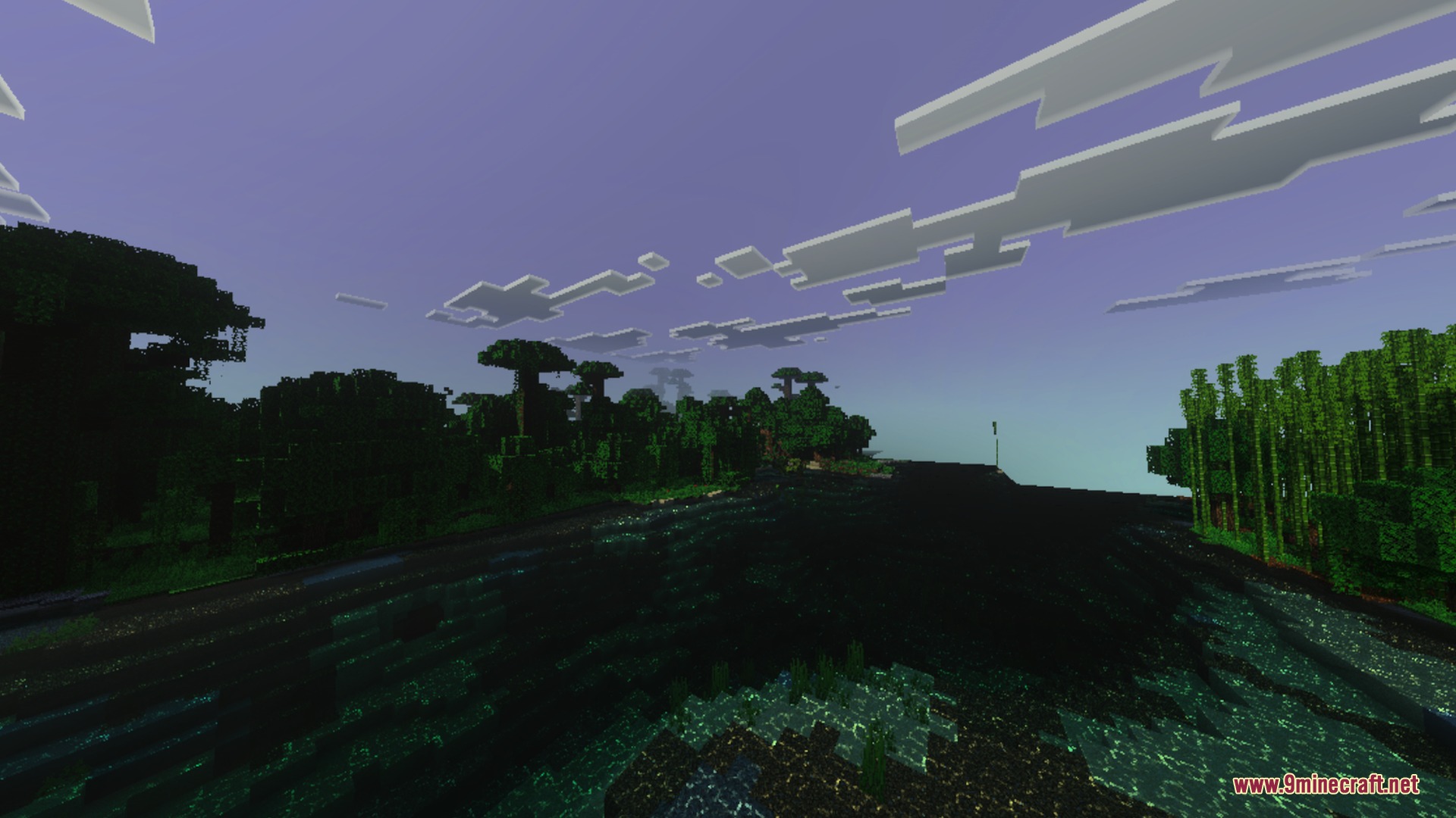 Lush jungle trees reflecting on dark water under a dim purple evening sky