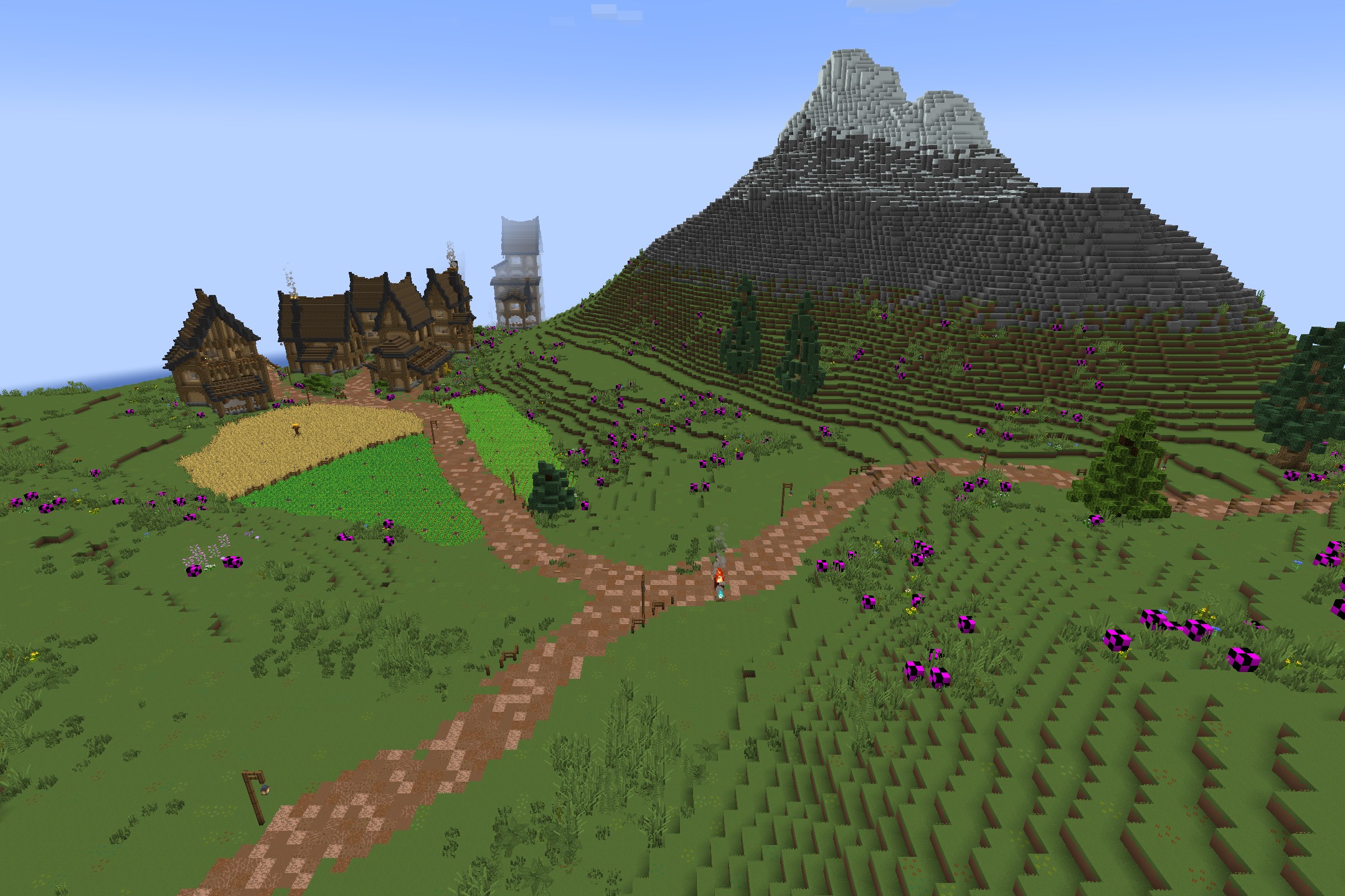 Peaceful village with wooden houses and crop fields under a large mountain