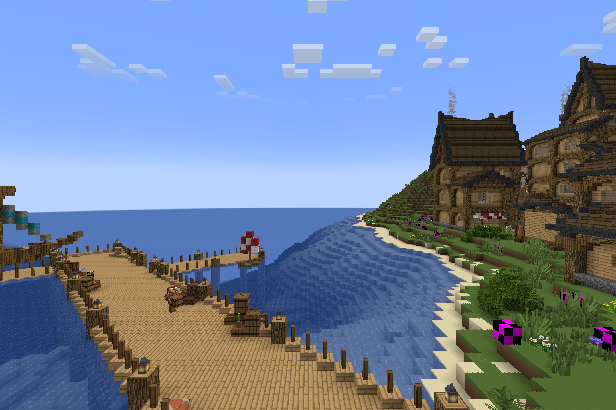 A wooden pier extends into the sea near a peaceful coastal village