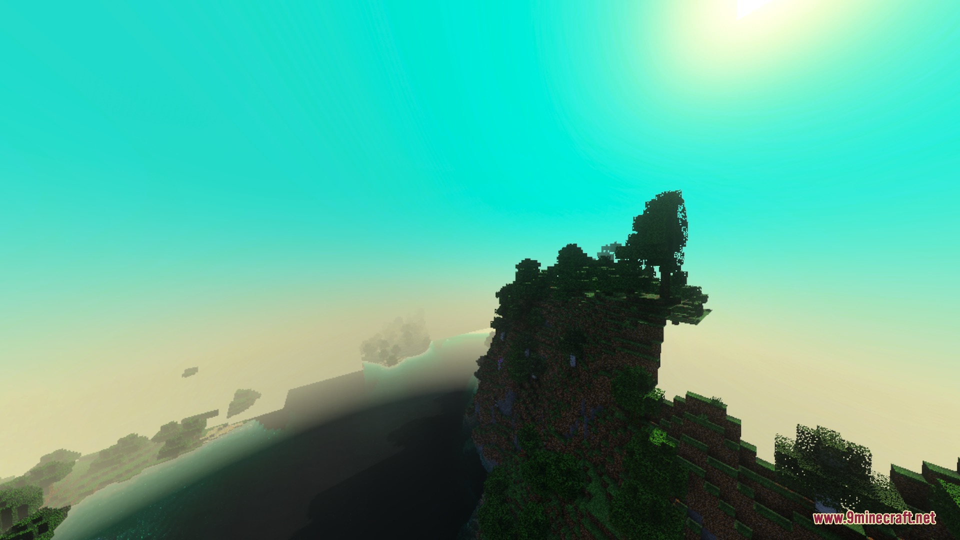 A high cliff with trees overlooking a vast landscape under golden sunlight