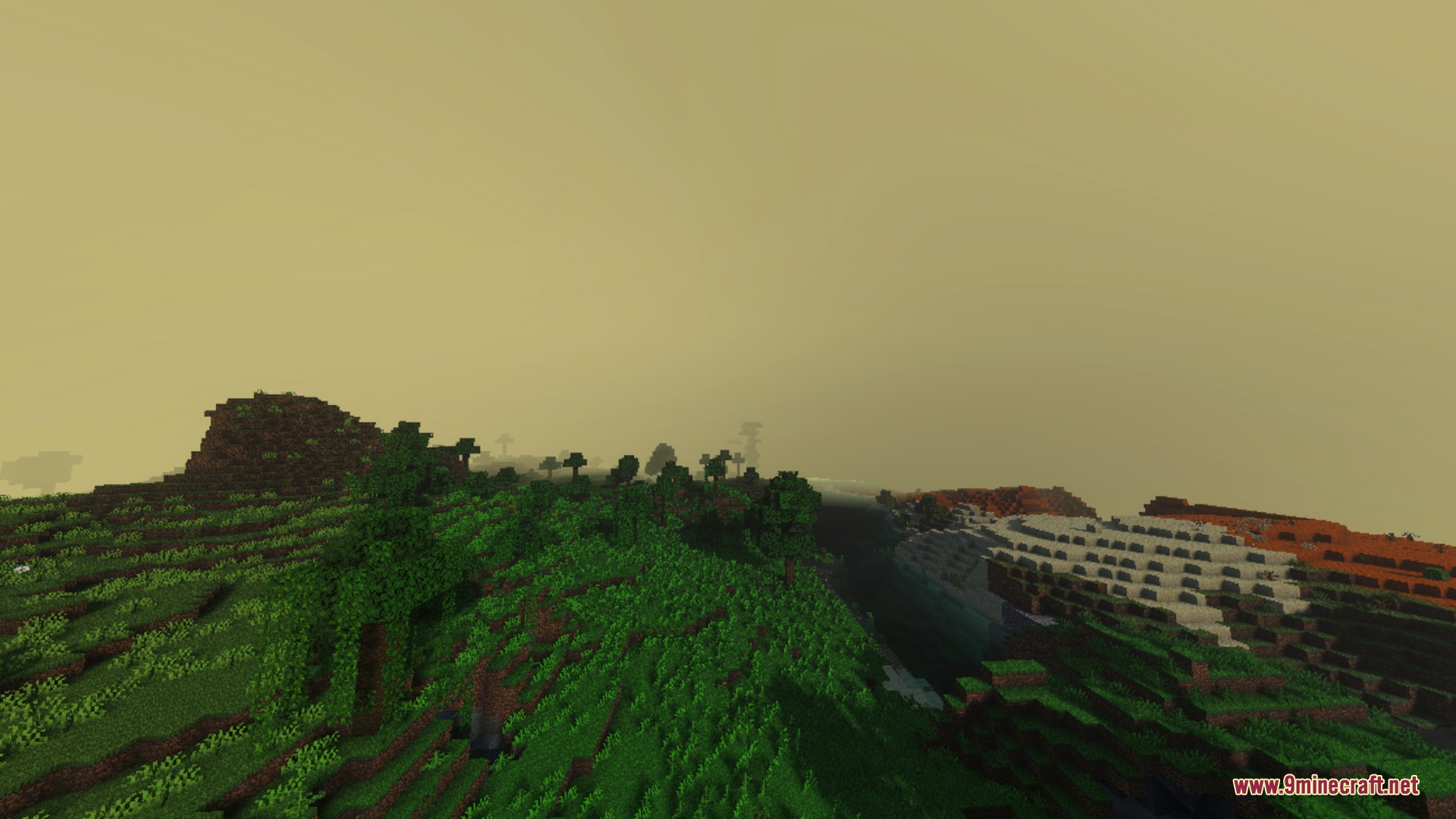 Lush green hills and a deep valley under a warm golden hazy sky