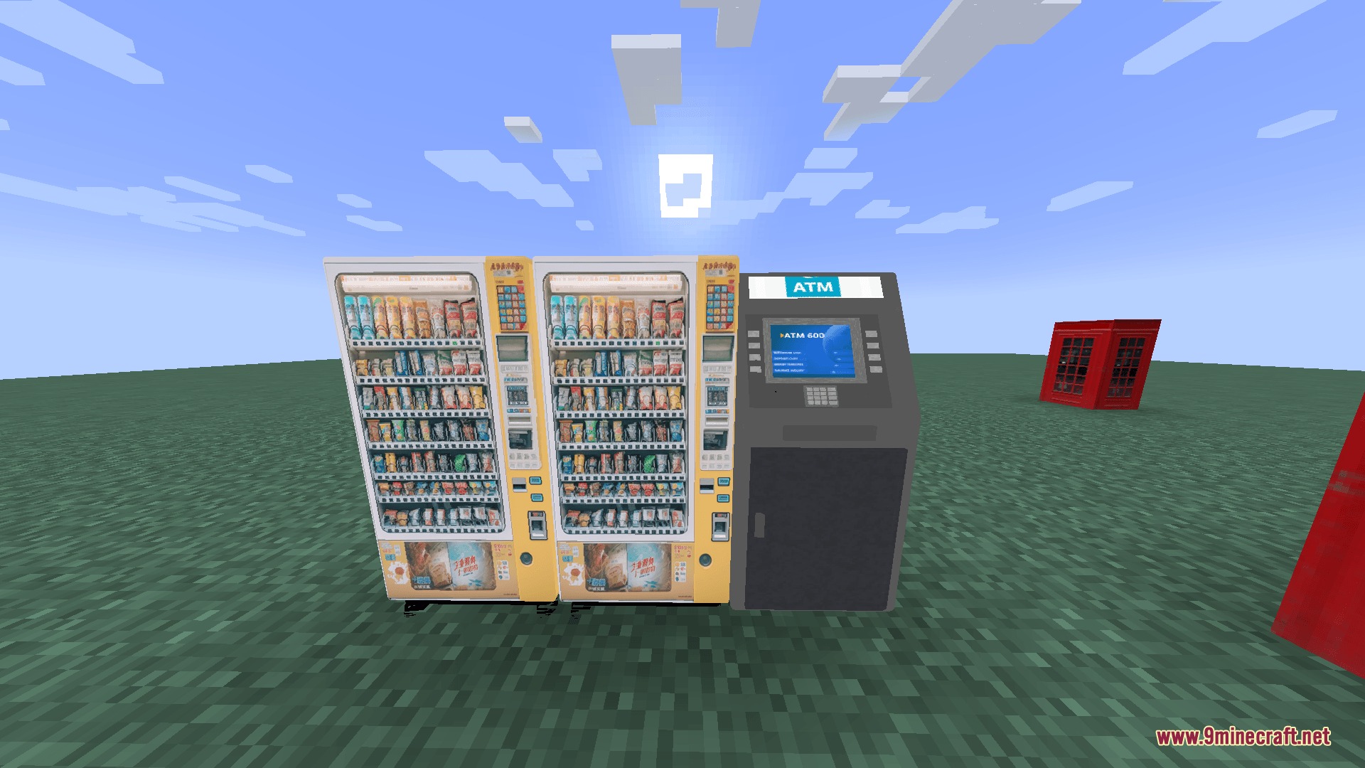 Two yellow vending machines and a grey ATM standing on the grass