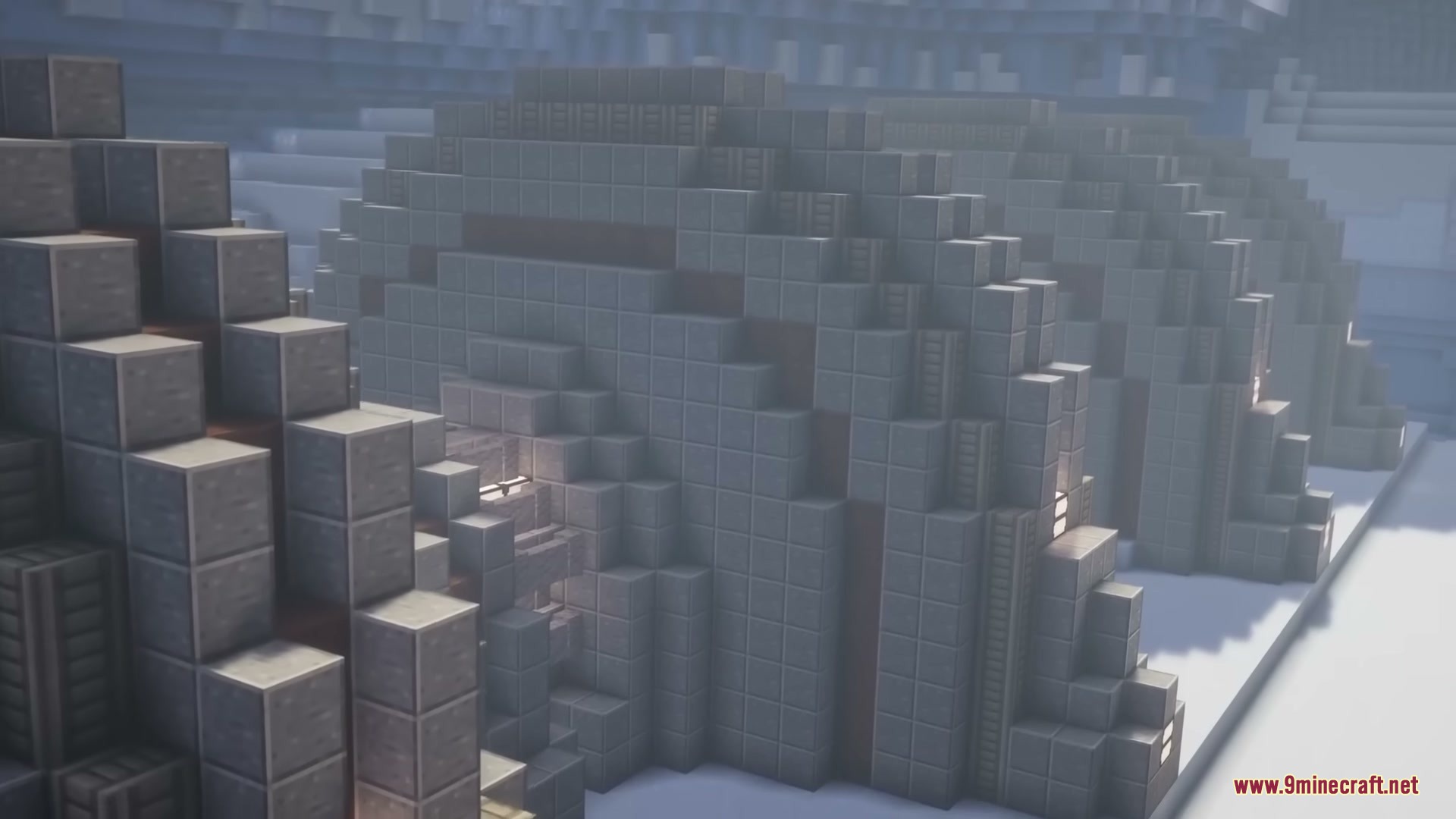 Several grey dome buildings stand together in a snowy Minecraft landscape