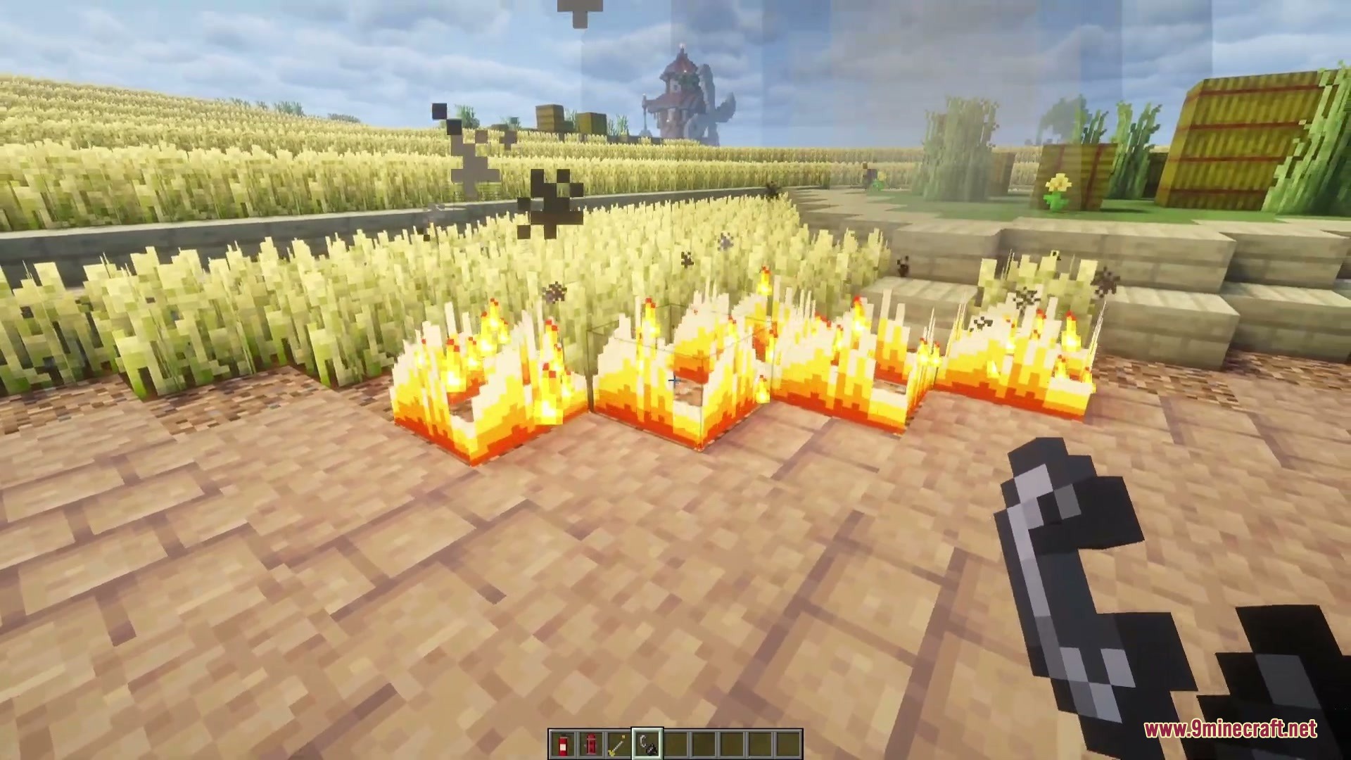 Wildfire spreading through a wheat field as the player holds flint and steel