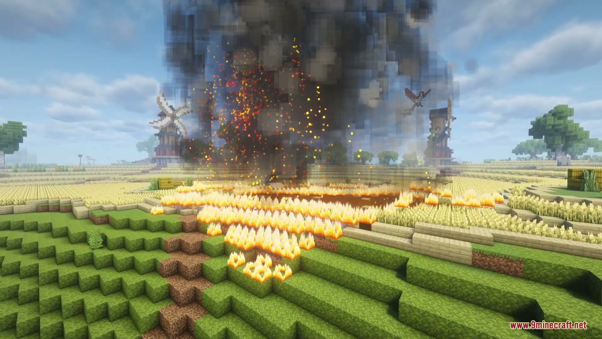 Intense flames create a thick smoke plume over a burning golden wheat field
