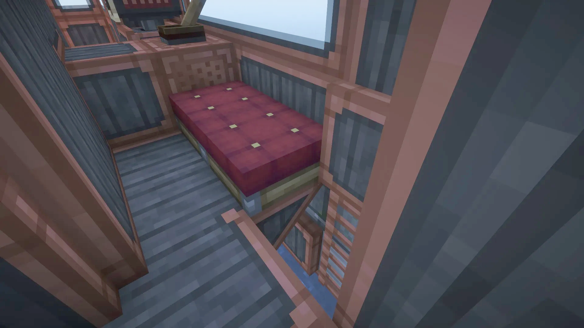 Cozy interior of a submarine cabin featuring a red bed and ladder