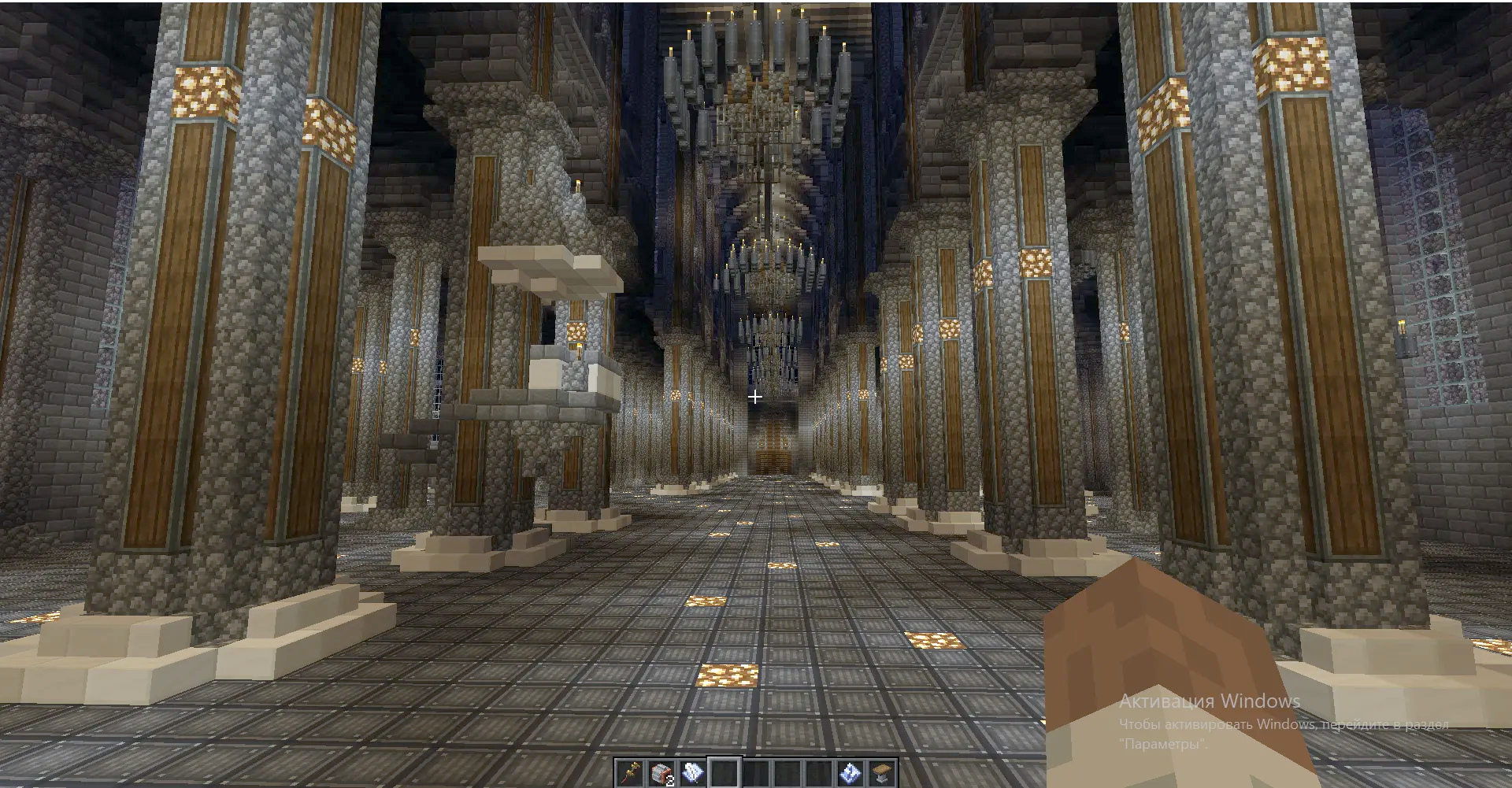 Interior view of a grand hall with tall pillars and hanging chandeliers