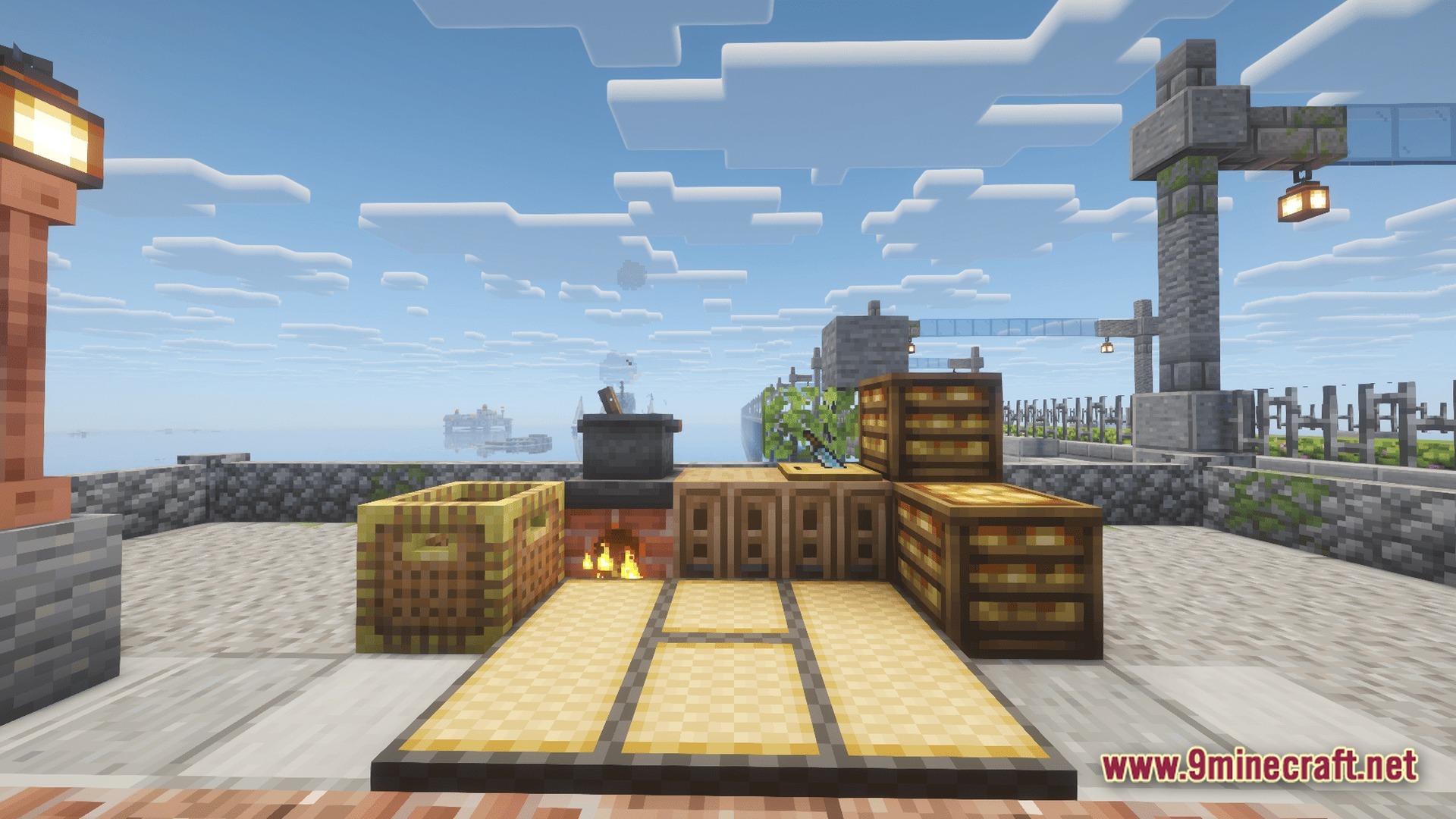 Take A Look GUNS Remasterd Modpack Screenshot 5 An outdoor kitchen area featuring a cooking pot, stove, and storage crates overlooking the ocean