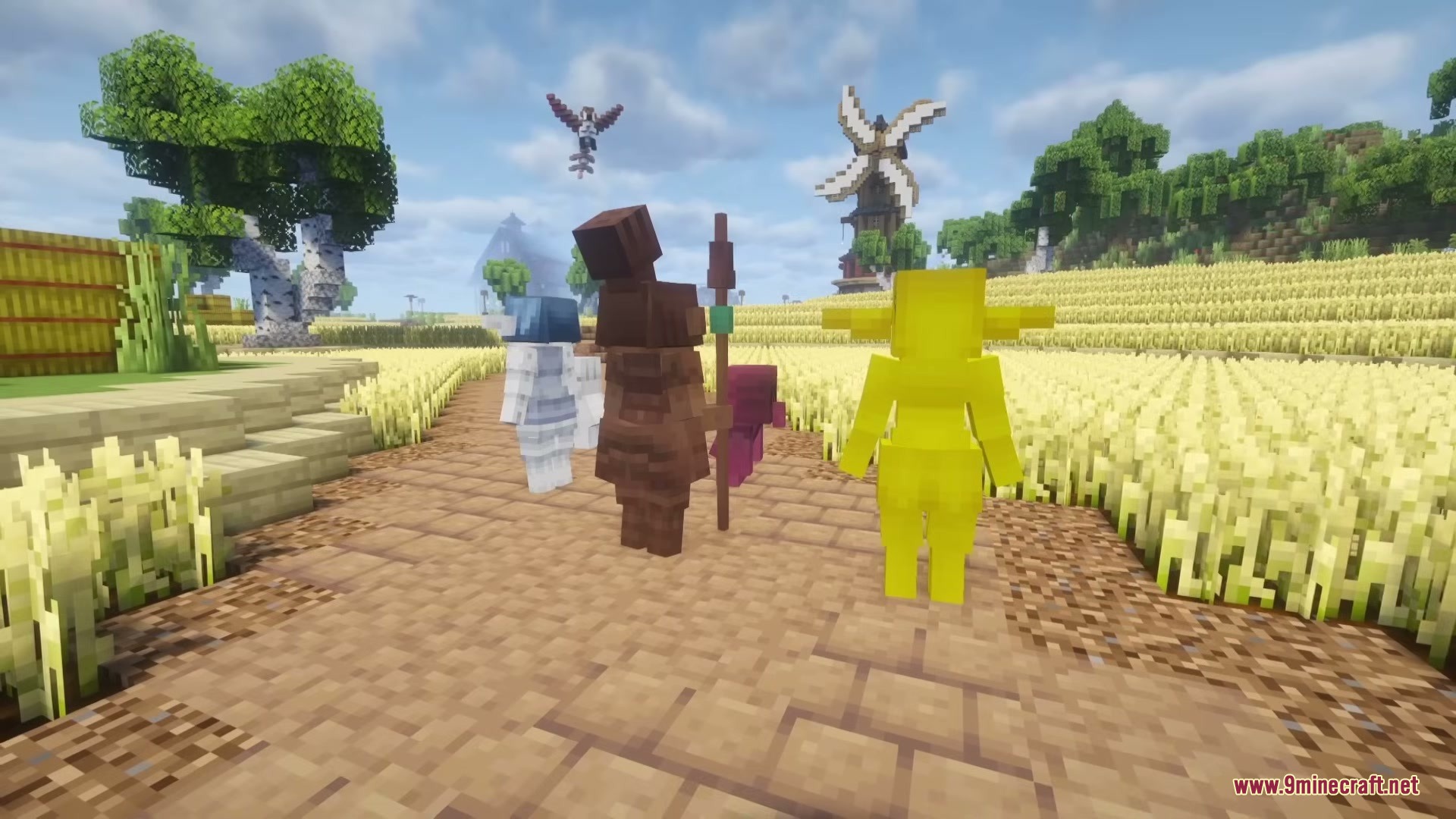 Various clay minions standing on a path next to a golden wheat field