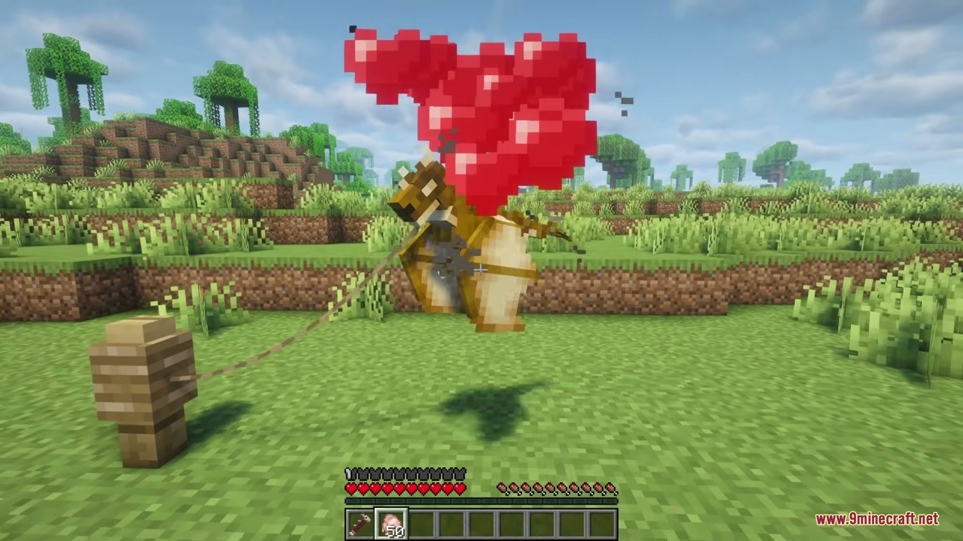 A tiny dragon tied to a fence post displays red heart particles
