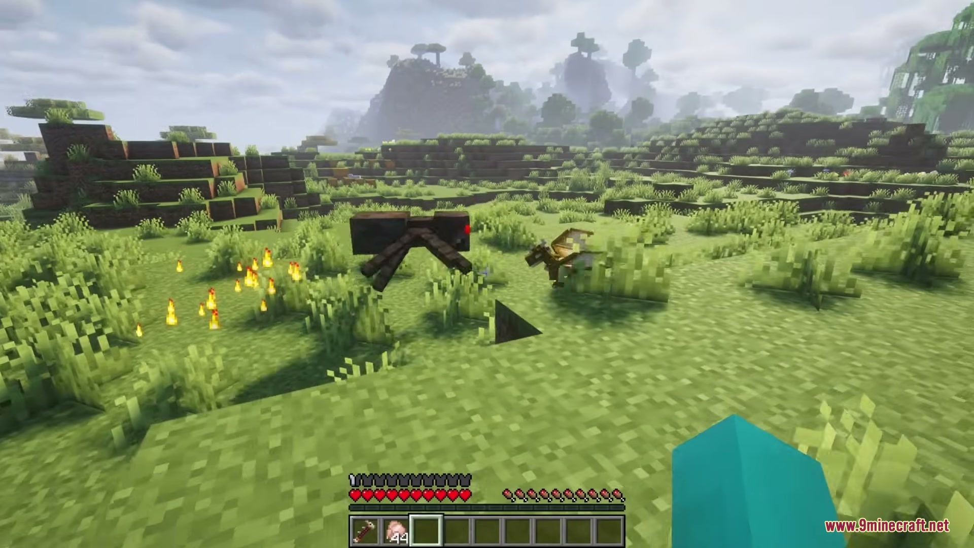 A tiny dragon fighting a spider while fire burns on the ground