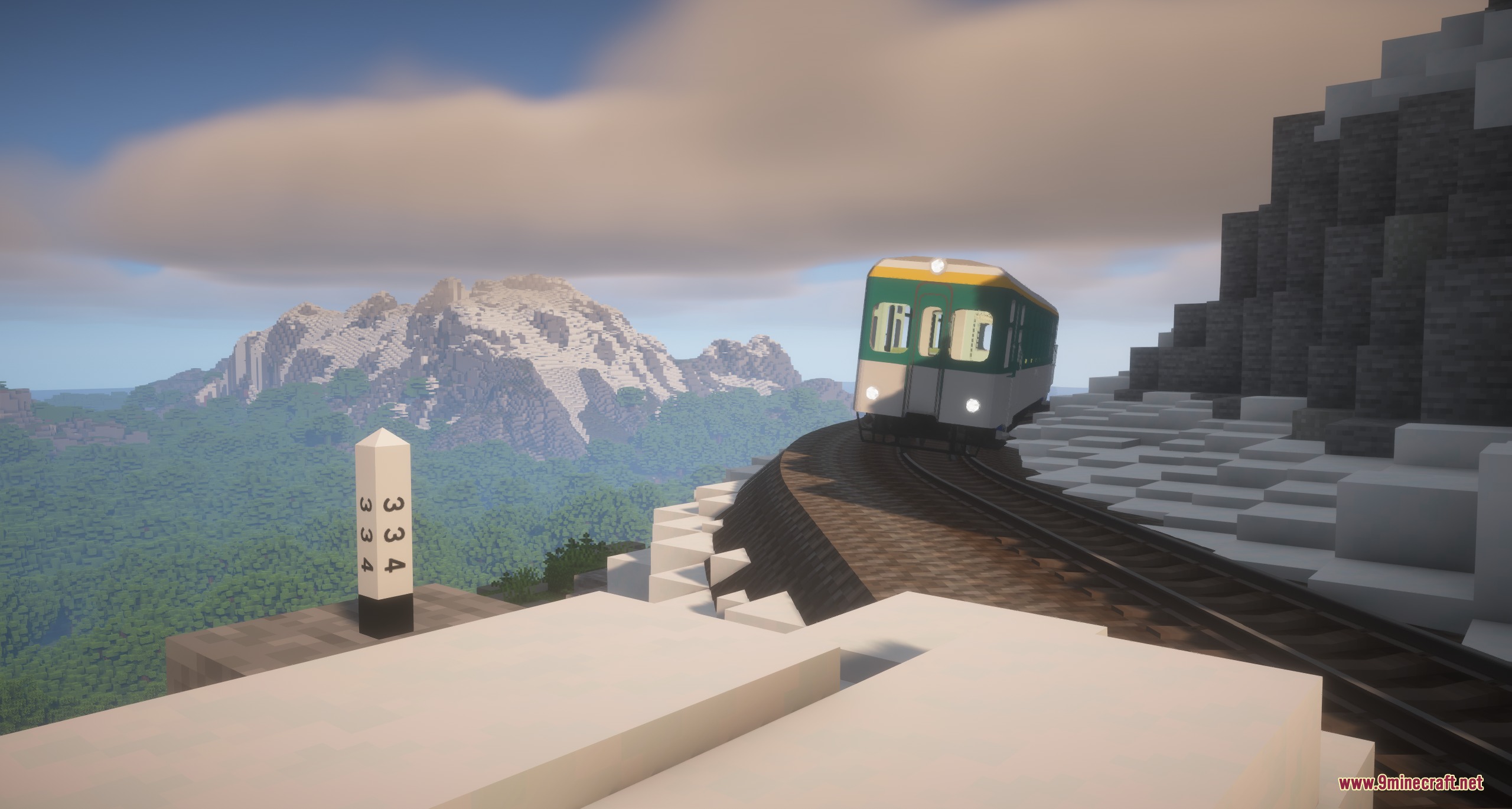 A green train traveling along a curved track on a snowy mountain side
