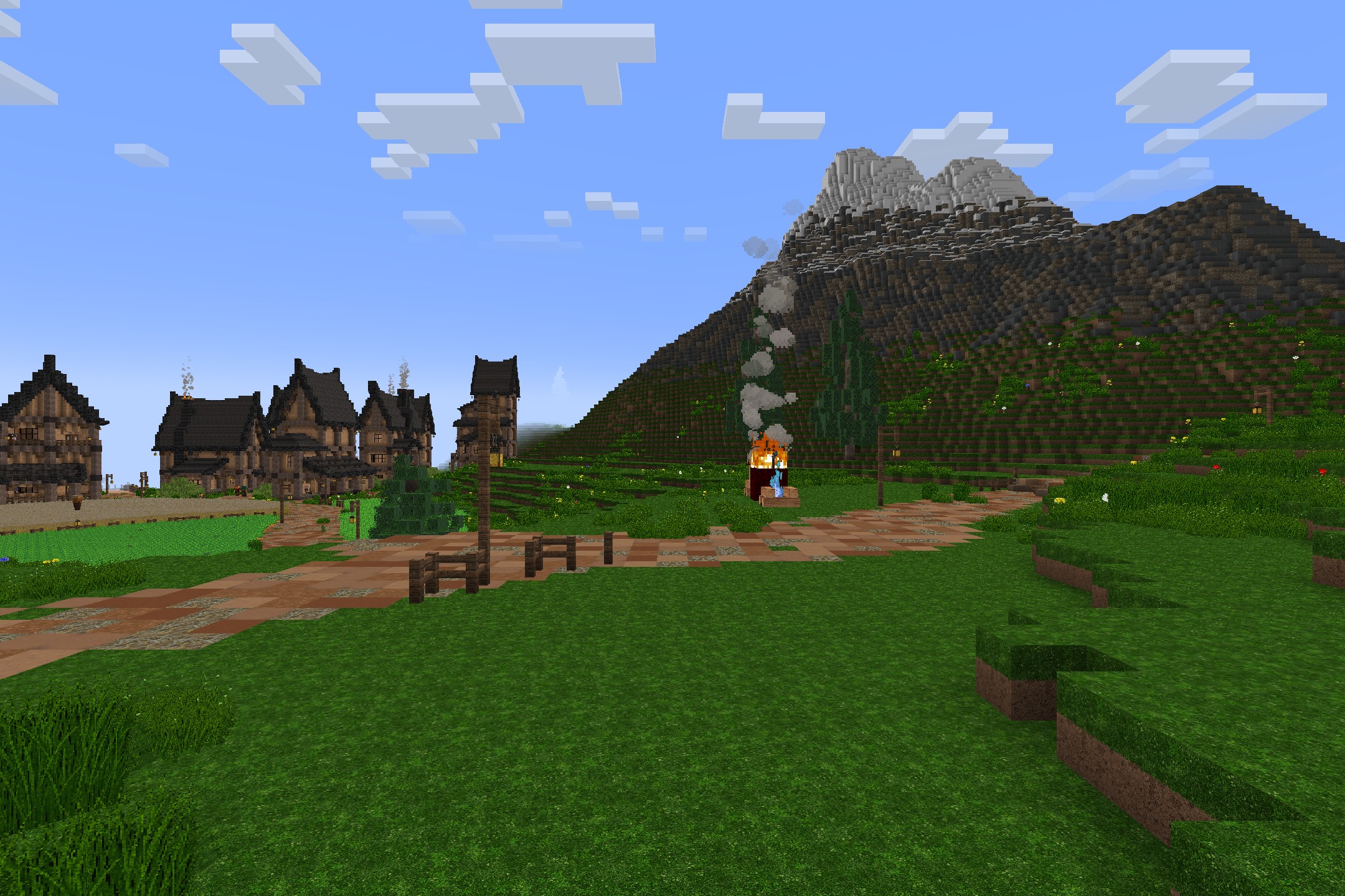 Smoke rises from a campfire near a path and medieval houses