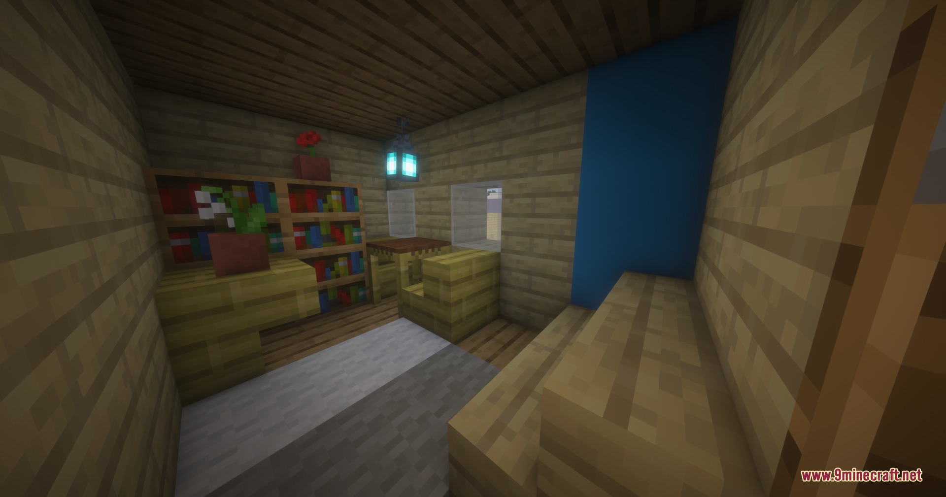 A furnished room featuring bookshelves a wooden table and a blue wall