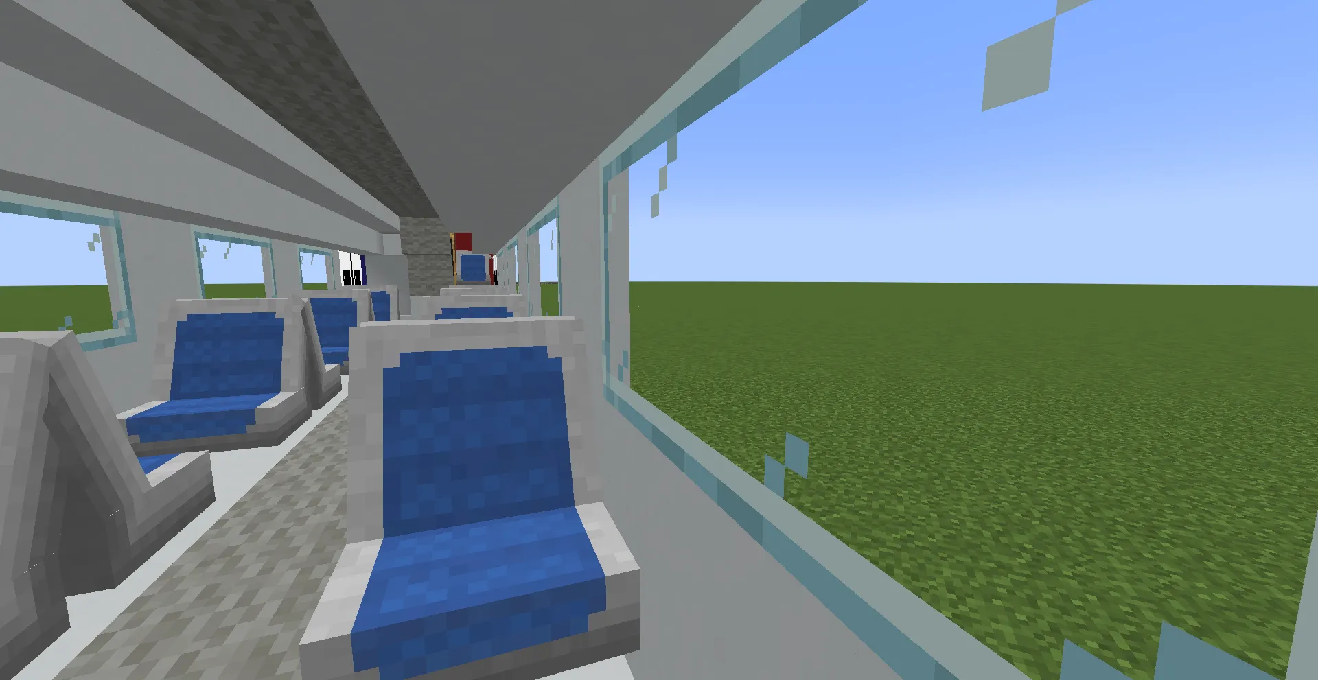 Interior of a passenger train car with blue seats and large glass windows