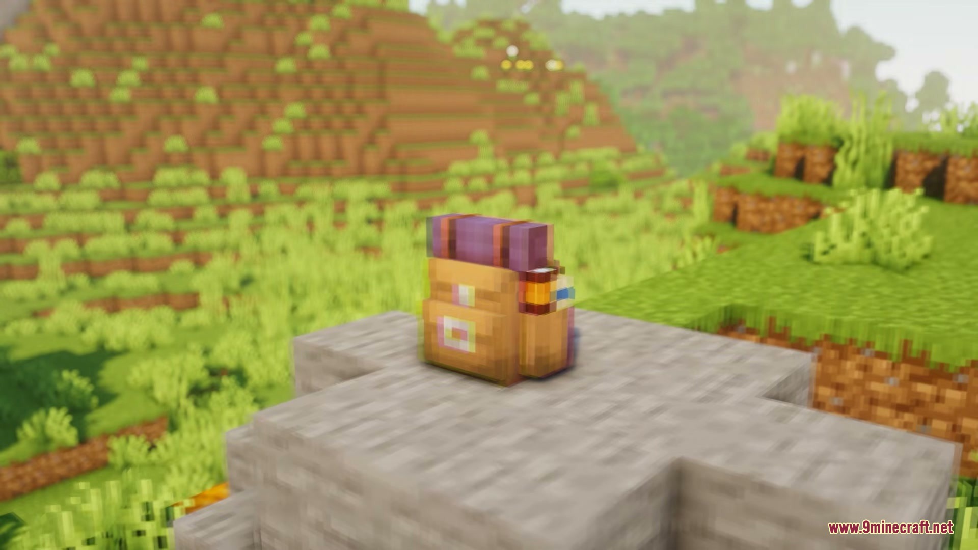 Vanilla Sophisticated Backpacks Resource Pack Screenshot 5 A brown backpack with purple straps sits on a stone block in a field