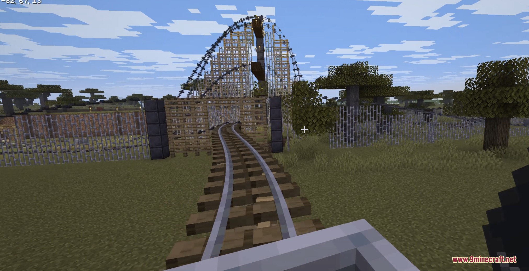 Minecart approaching a wooden roller coaster with automatic supports in a savanna biome