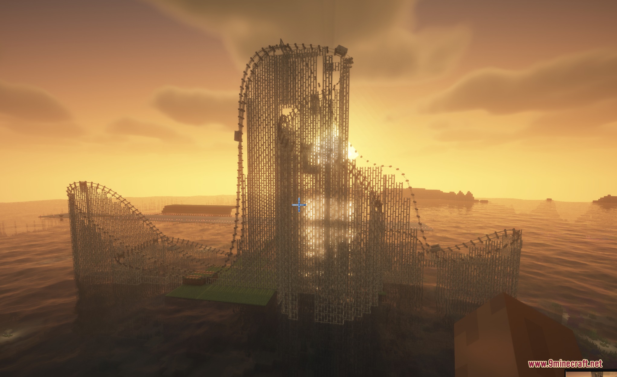 A massive wooden roller coaster with curved tracks stands over water at sunset