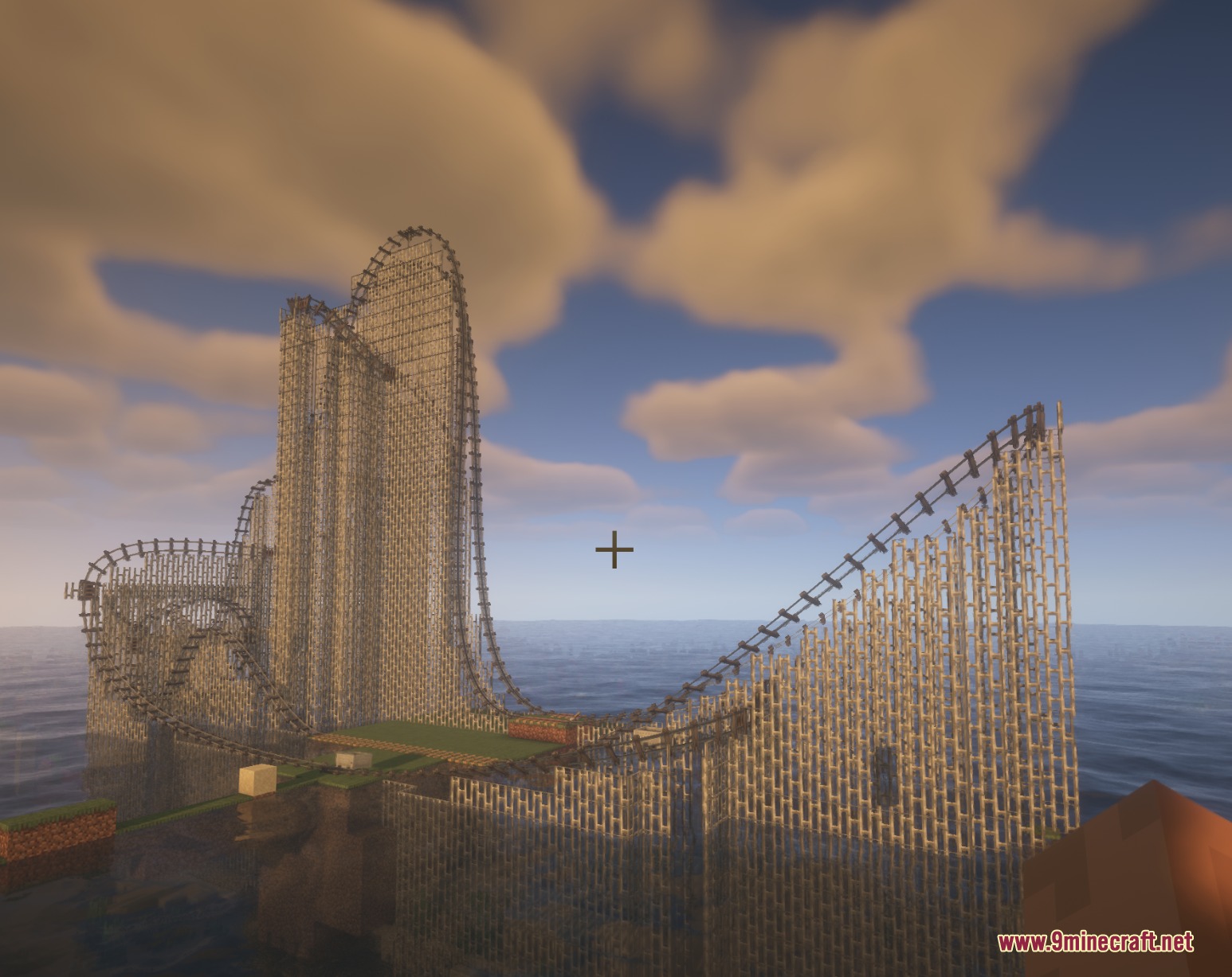 A steep roller coaster track with wooden supports built over a vast ocean