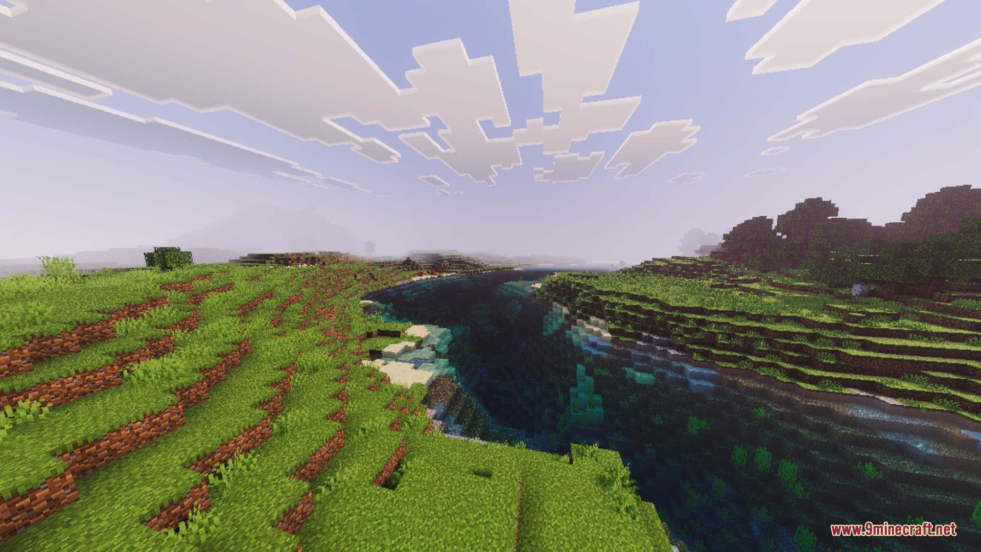 Lush green hills and a deep river canyon under a bright cinematic sky