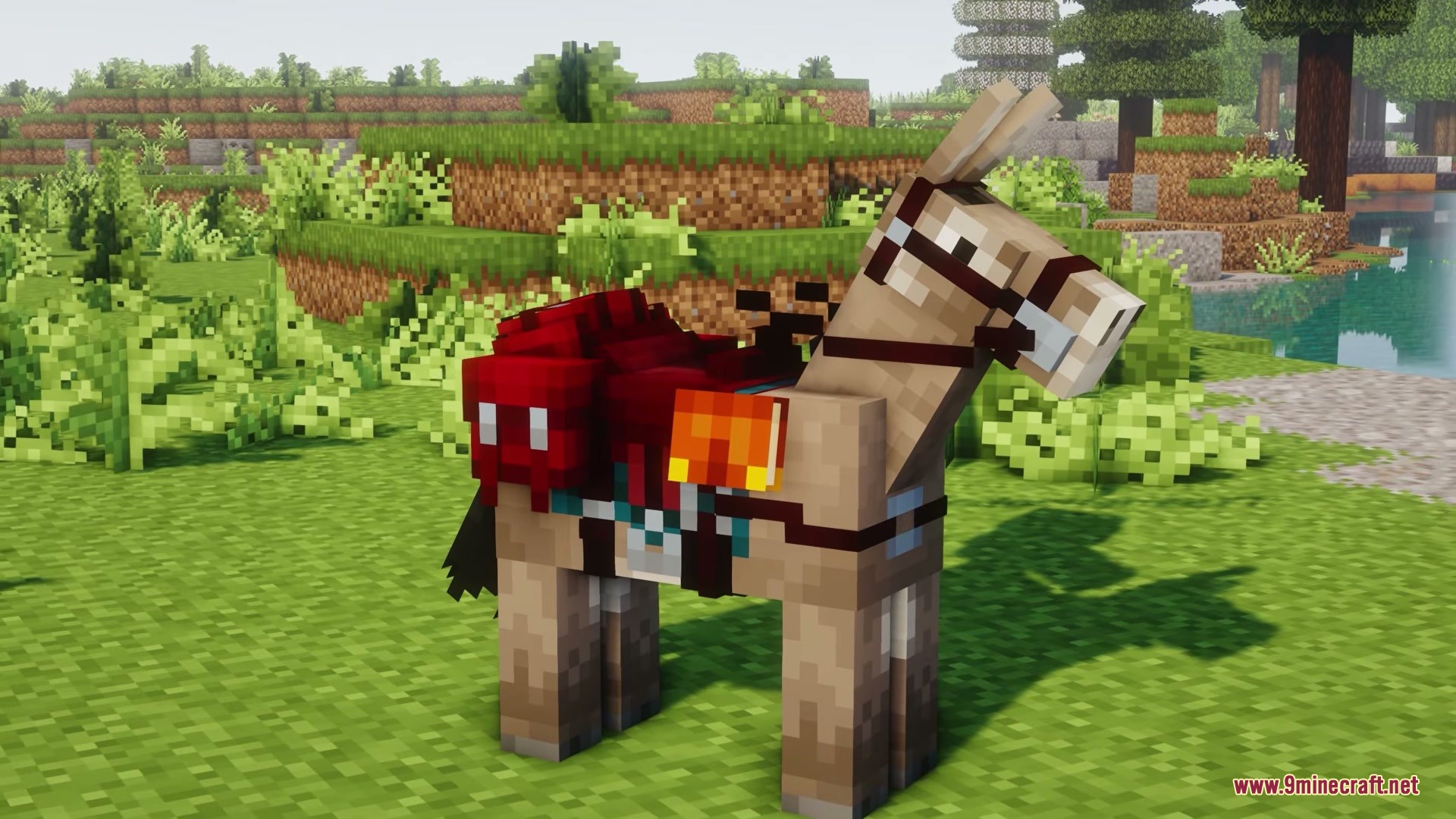 Donkey with red saddlebag and travel gear standing in a grassy field