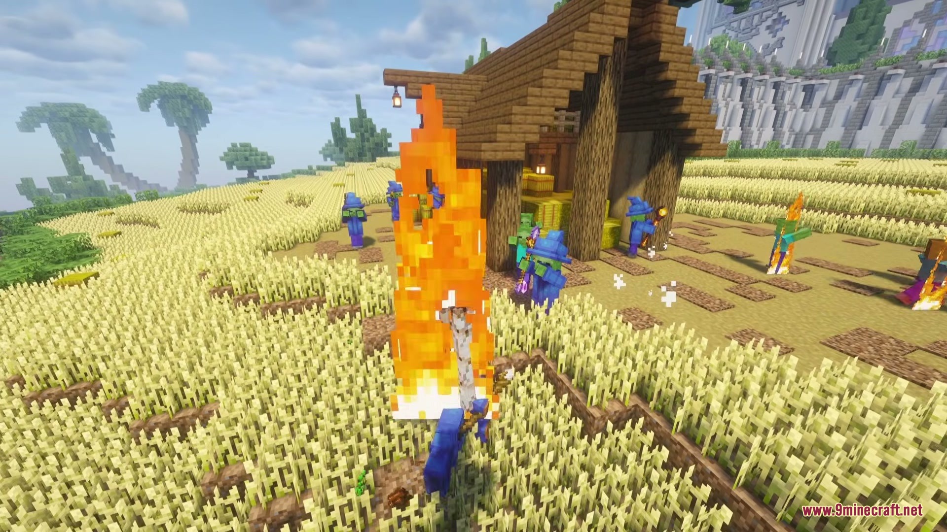 Wizard Mobs Mod Screenshot 1 Zombie wizards in blue robes standing around a fire in a wheat field