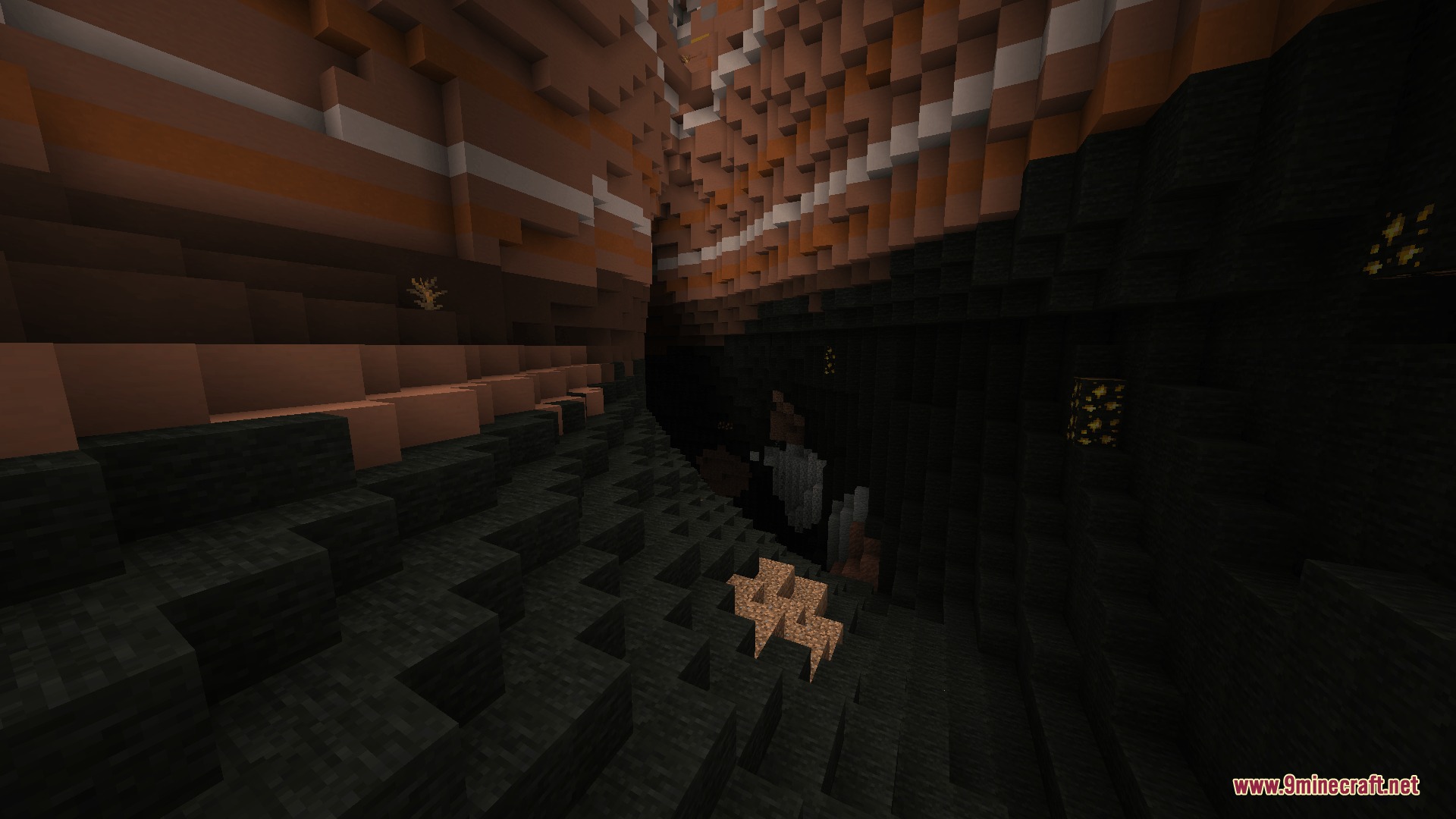 Deep cave featuring colorful sedimentary rock layers and dark stone floors
