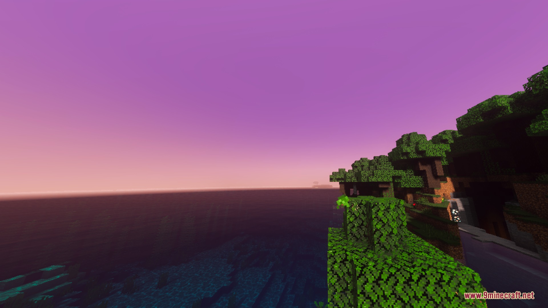 Lush green trees on a cliff overlooking the ocean at purple sunset