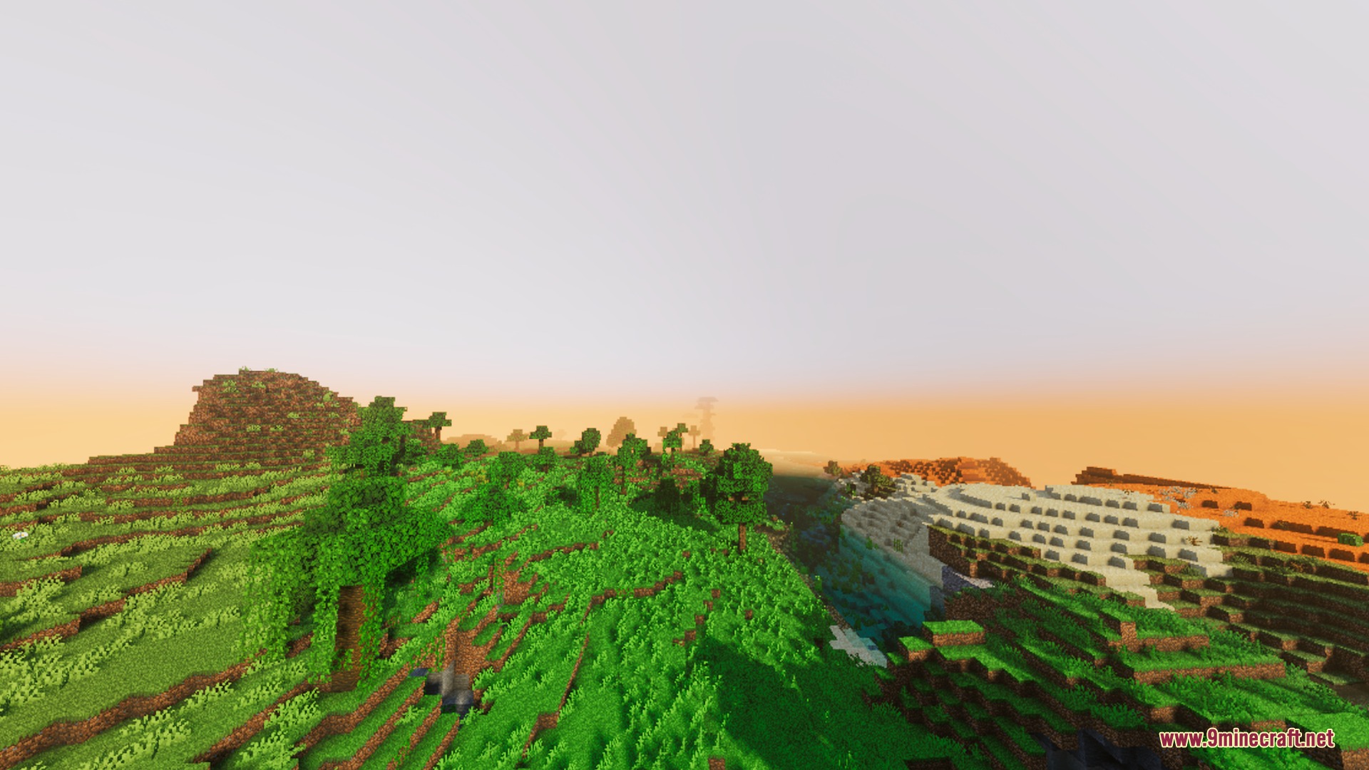 Lush green hills stretching toward a horizon filled with warm volumetric fog