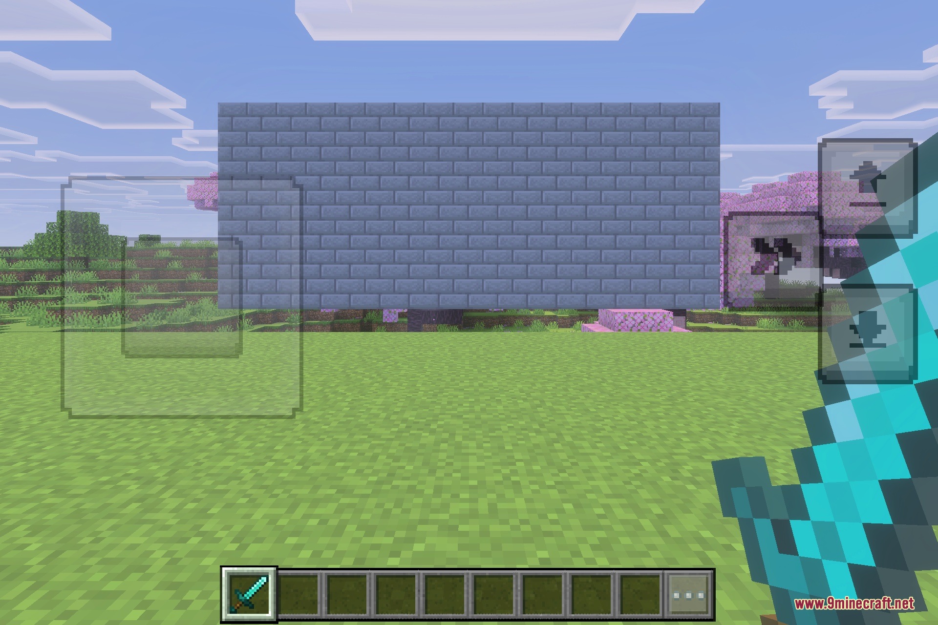 Player holding a diamond sword in front of a large stone brick wall