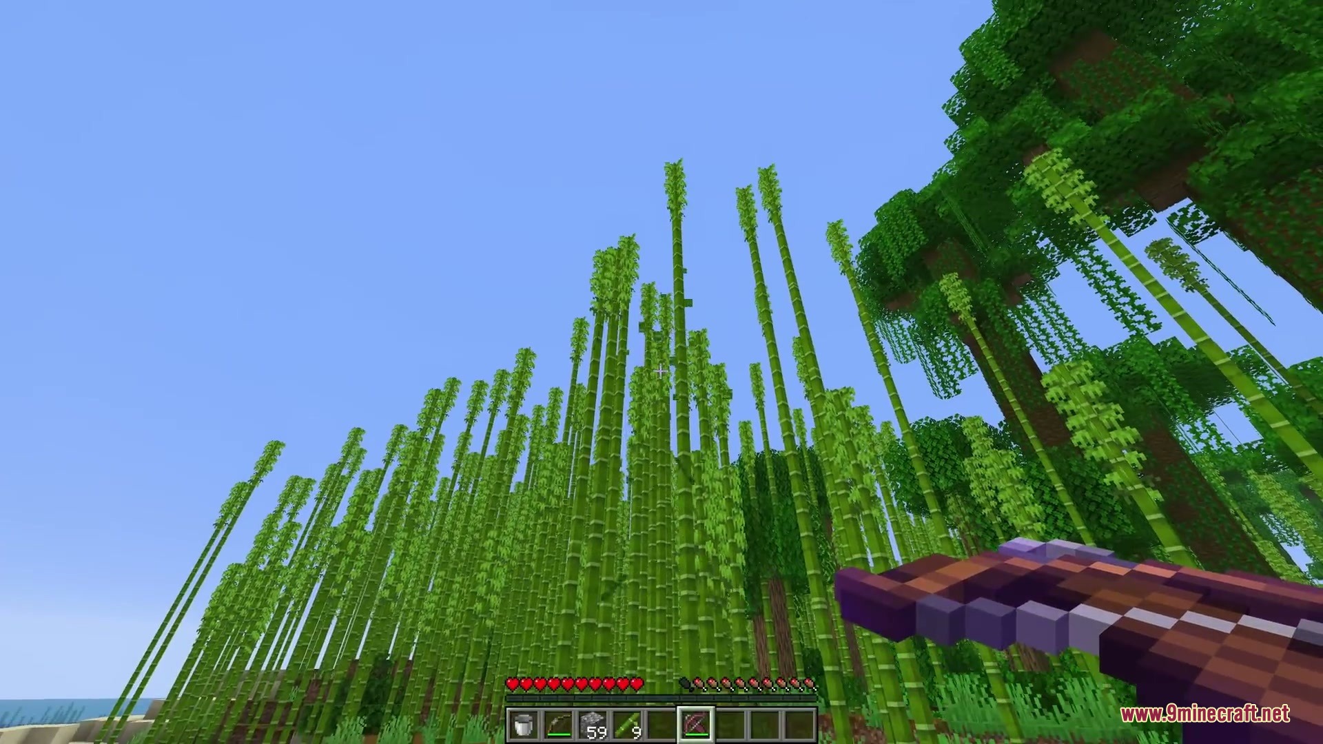 Ballistic Versatility Mod Screenshot 4 The player holds an enchanted crossbow while looking up at tall bamboo