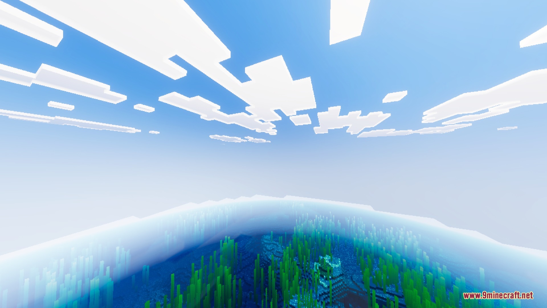 Clear blue ocean water with green kelp and a structure under bright clouds