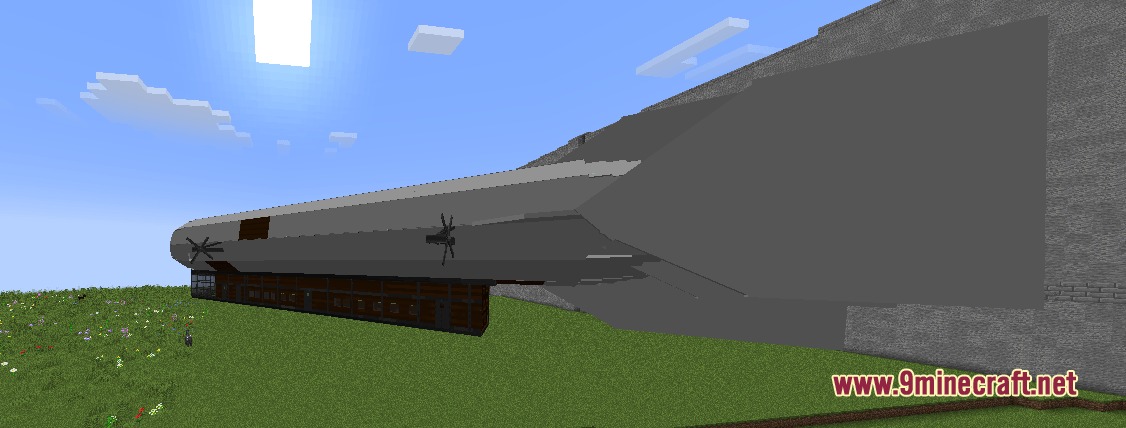Colossal Origins Expanded Mod Screenshot 4 A large grey airship parked on a grassy field near a wall