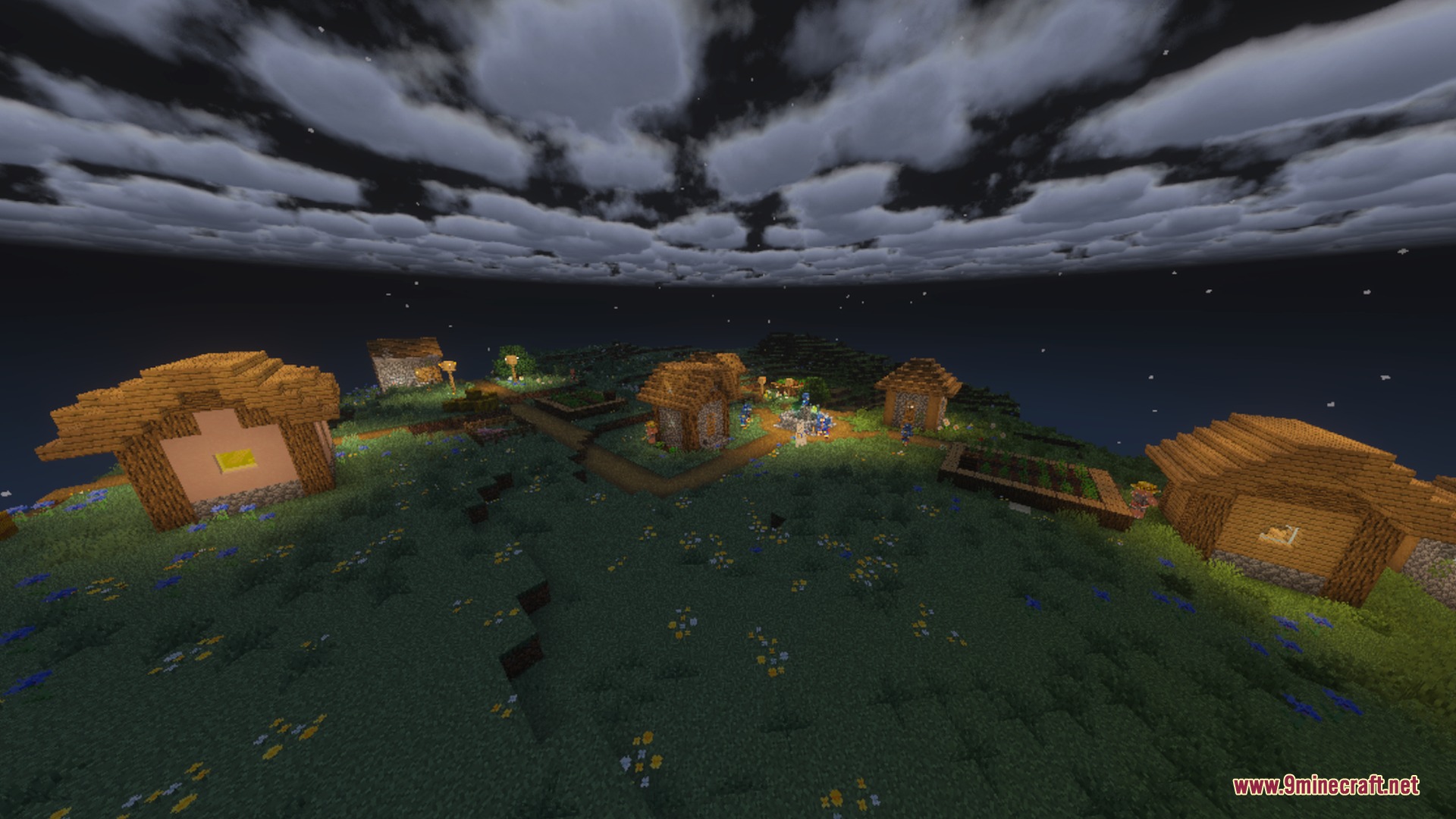 Small village at night under a dark sky with scattered soft clouds