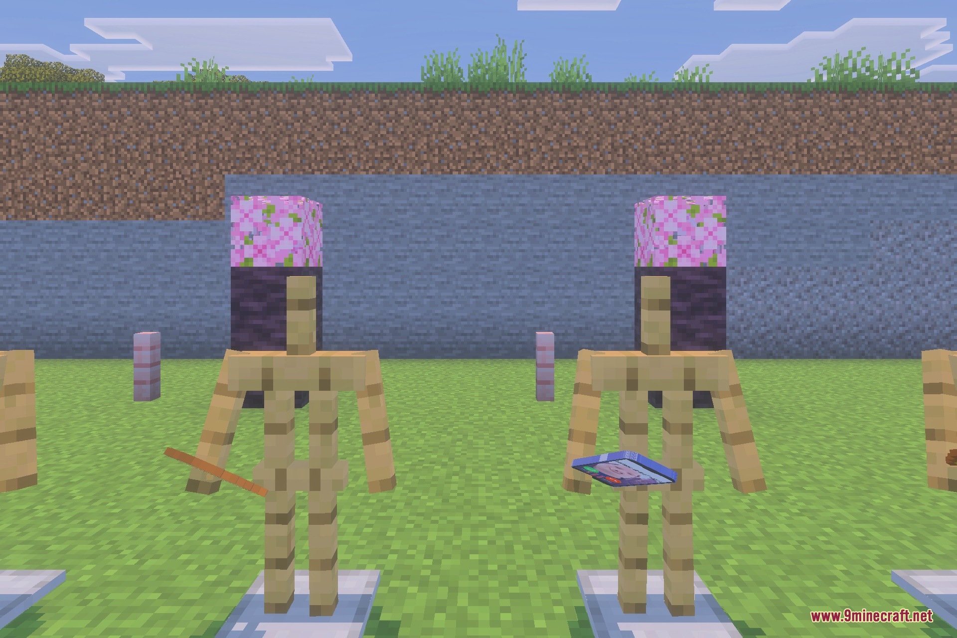 Two armor stands holding items with unique block heads in a field