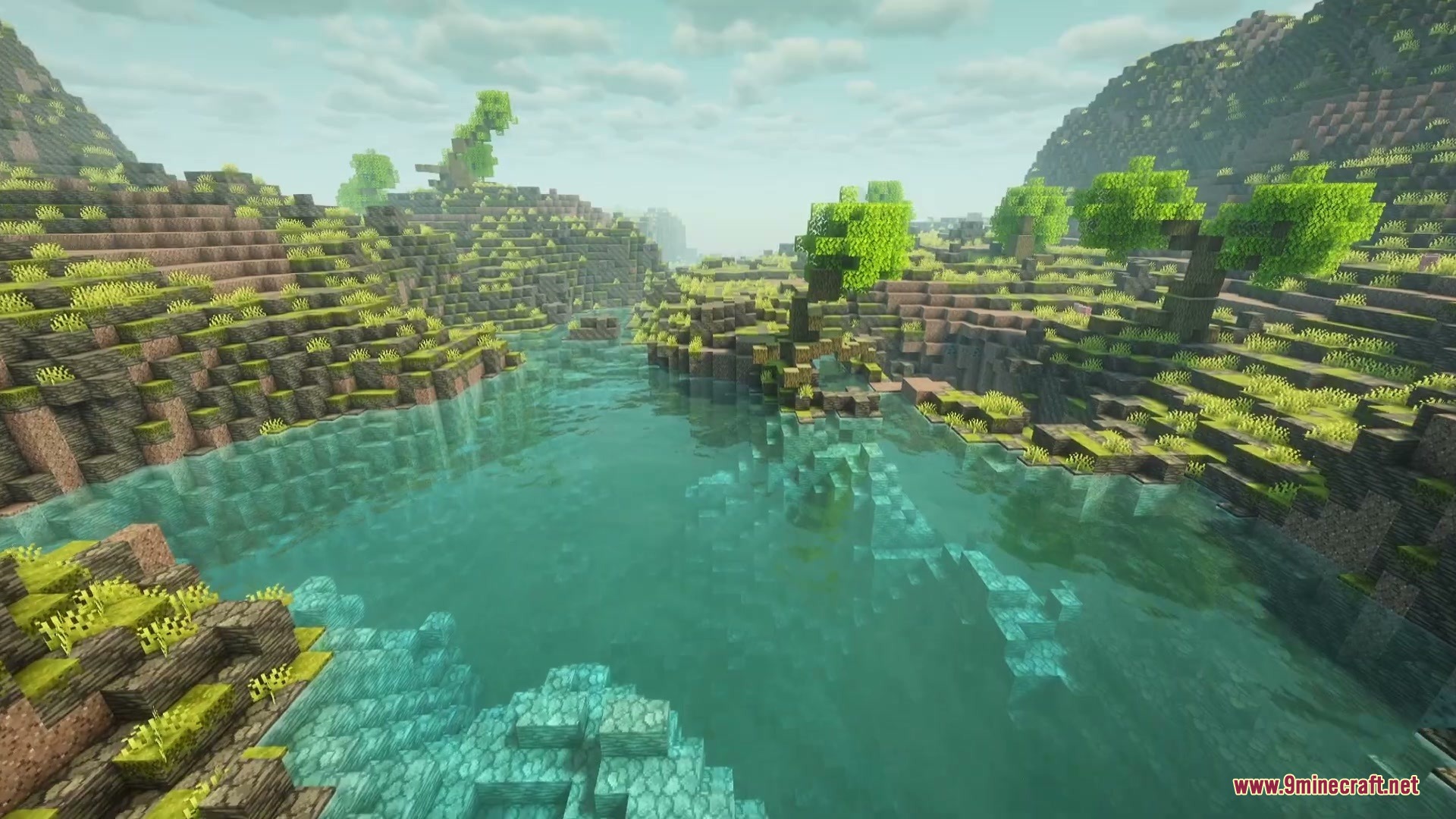 Clear turquoise water flows through a rocky Mediterranean landscape with lush green trees