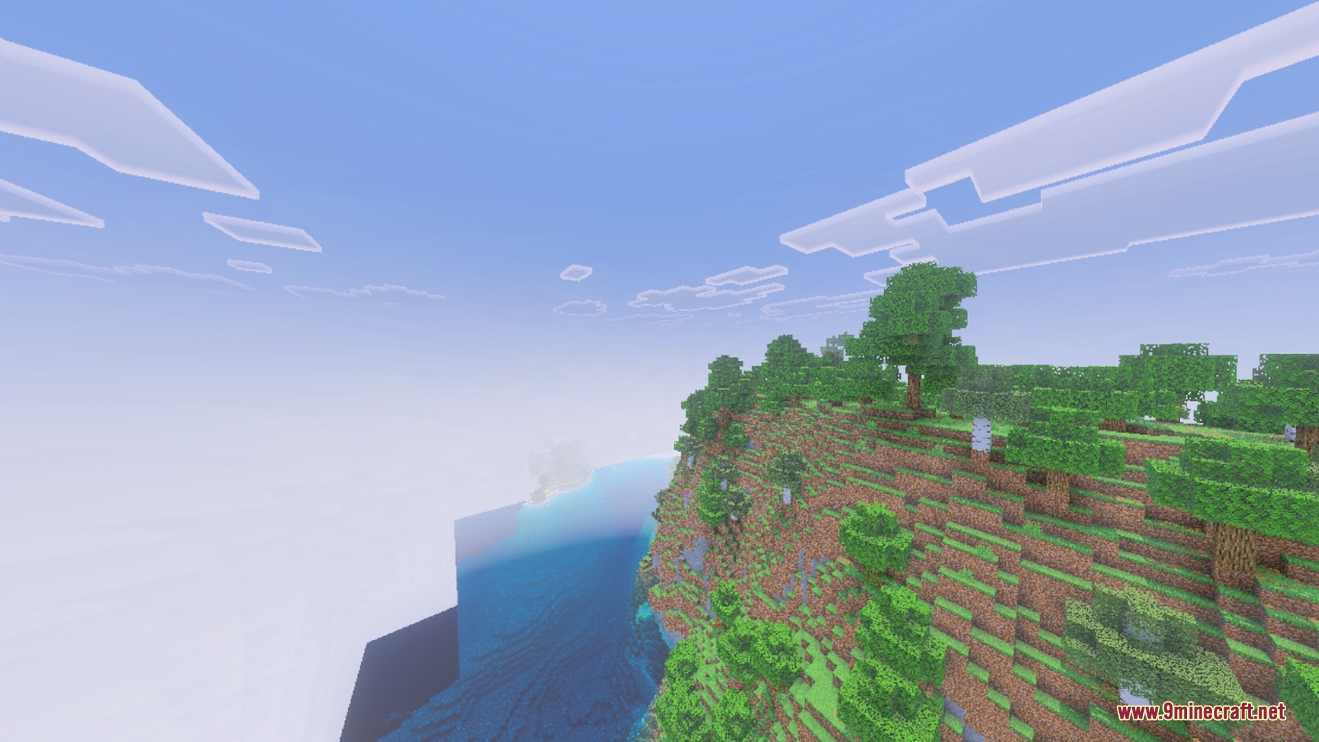 Lush green cliffs and trees overlook a vibrant blue ocean under a soft sky