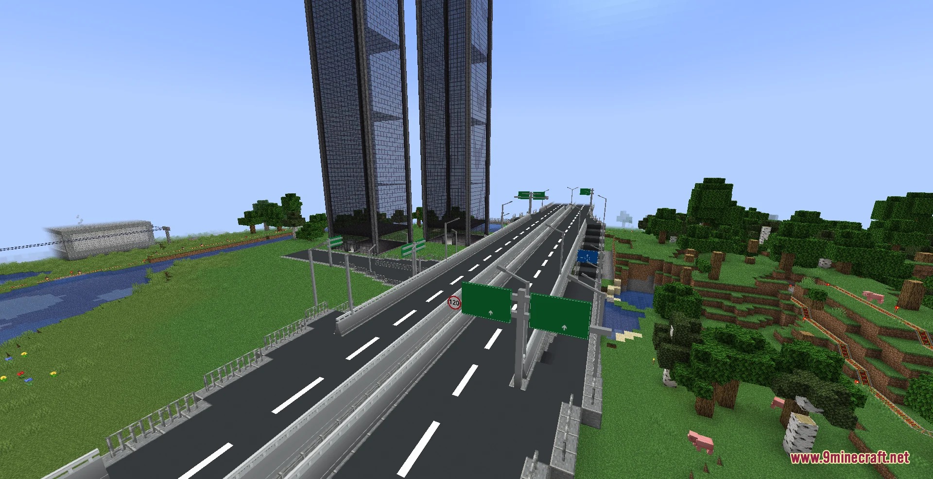 A modern multi lane highway with green overhead signs and tall glass skyscrapers