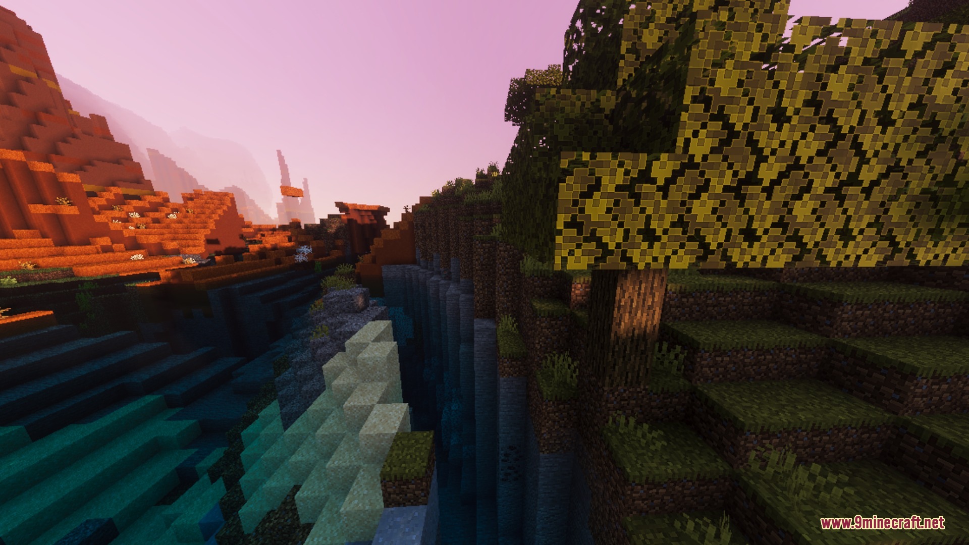 Vibrant sunset colors illuminating a deep canyon between two different biomes