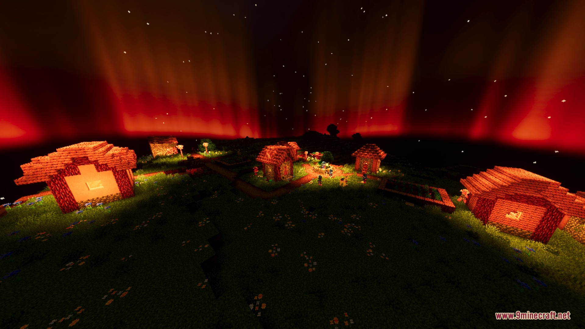 Small village houses illuminated by warm orange light under a crimson night sky